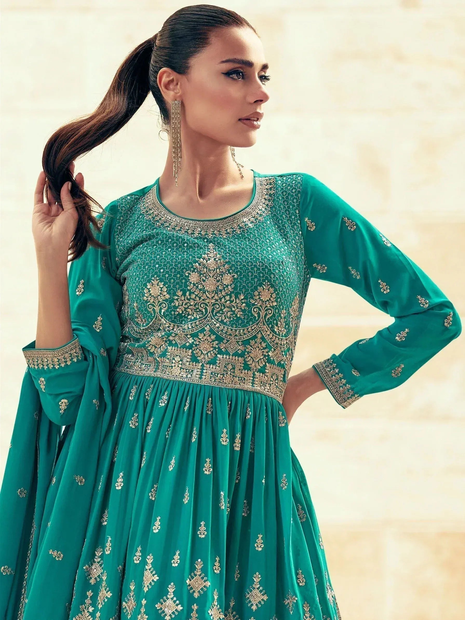 Emerald green embroidered ethnic gown with gold detailing, perfect for Indian occasions and festive wear.