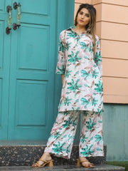 Woman in floral print kurta and palazzo set standing by a teal door, Ethnic Plus fashion