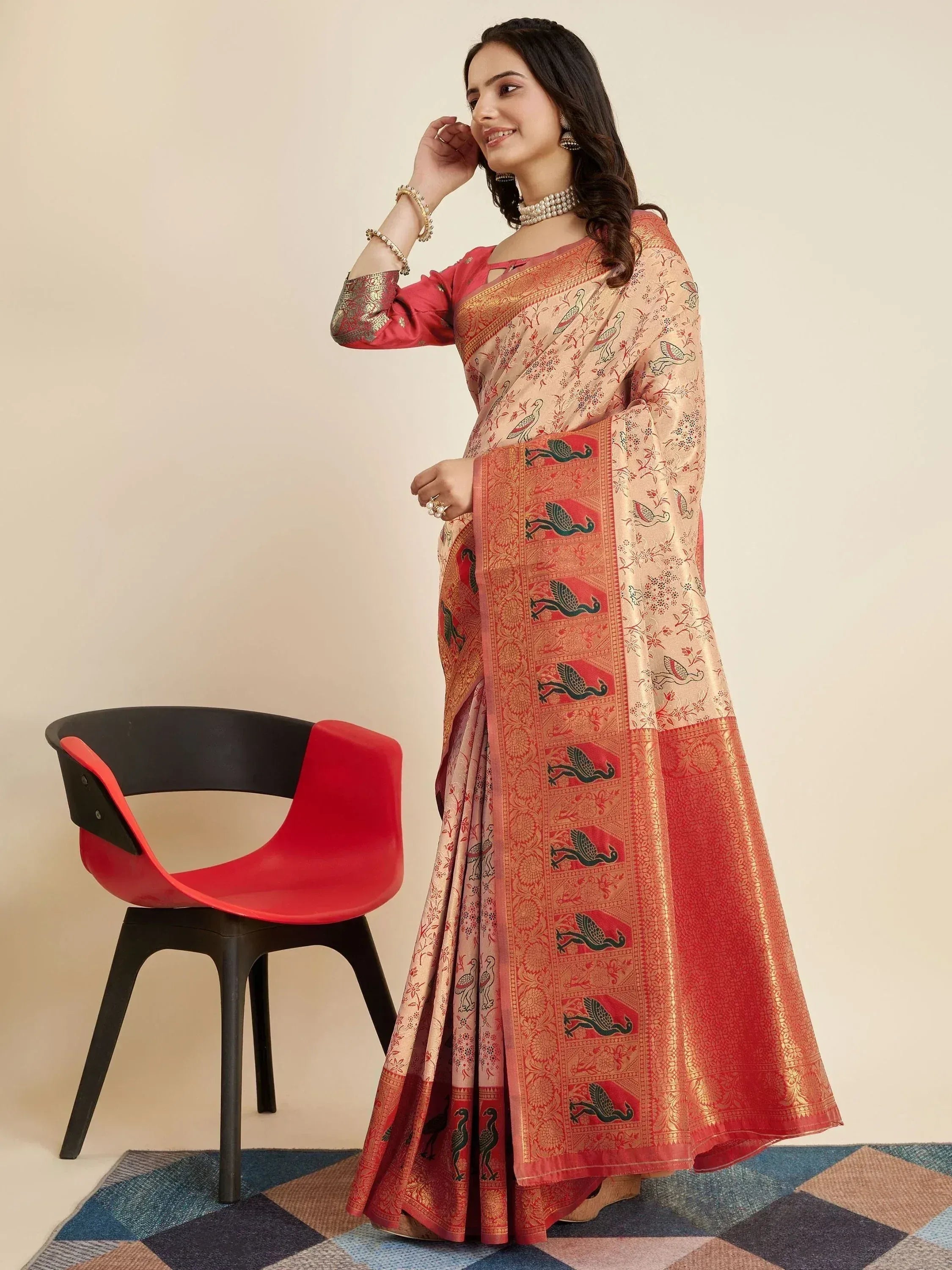 Woman in elegant Indian saree with bird print and gold border, paired with pink blouse for festive occasions