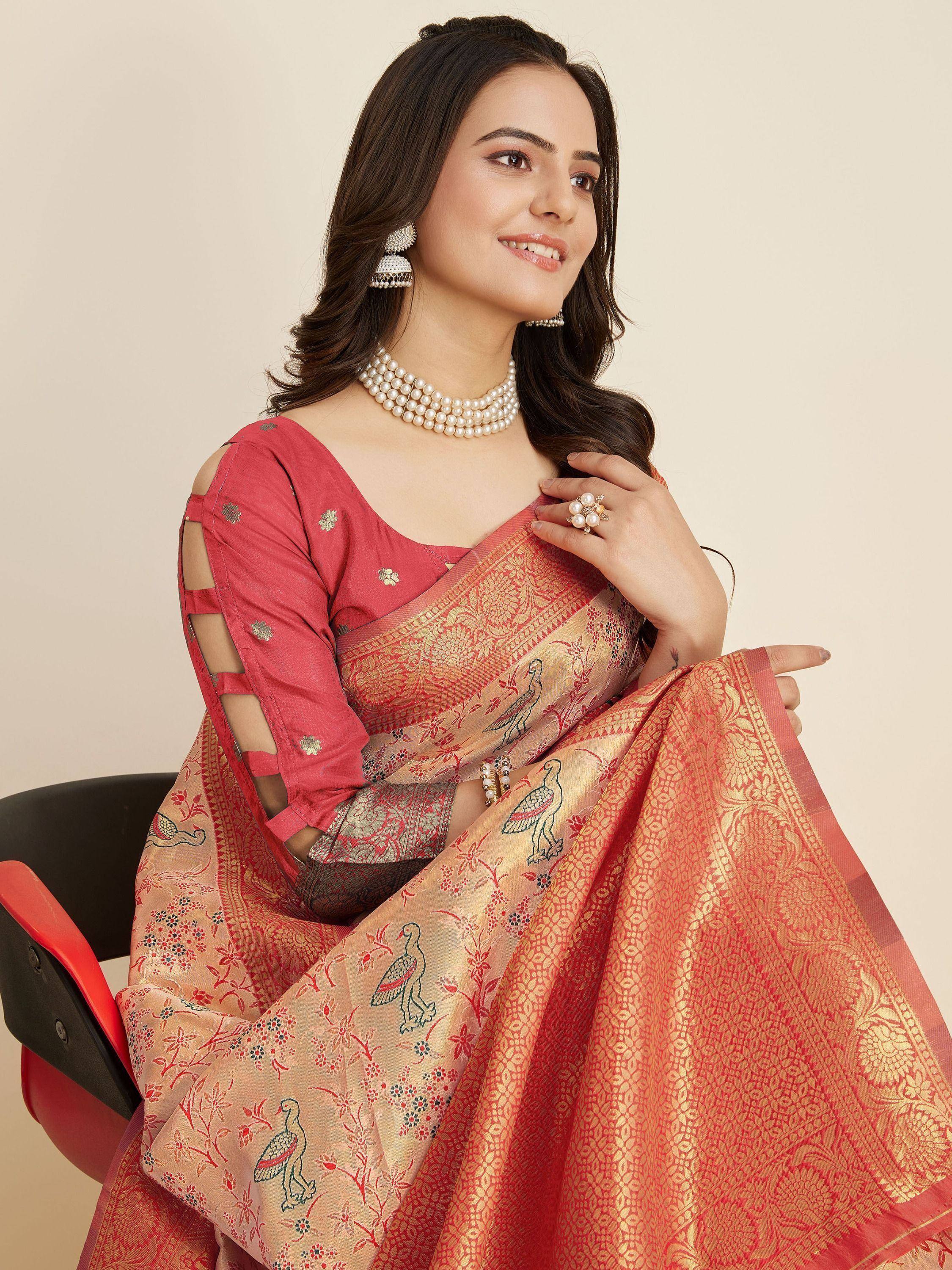 Woman in red and gold embroidered saree with bird motifs, paired with pearl jewelry and cut-out blouse