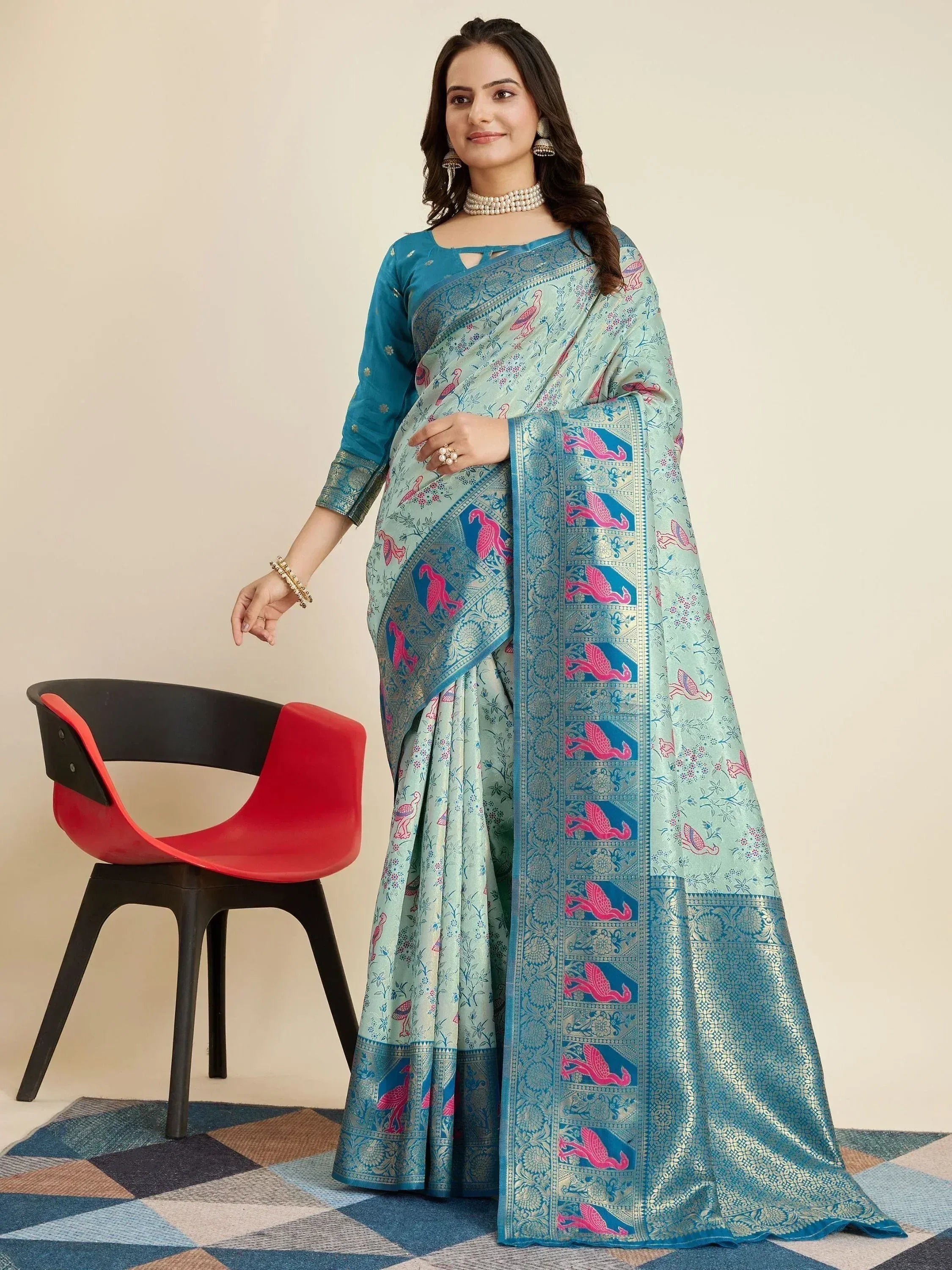 Woman in mint green saree with pink bird print and blue border, paired with teal blouse, ethnic wear