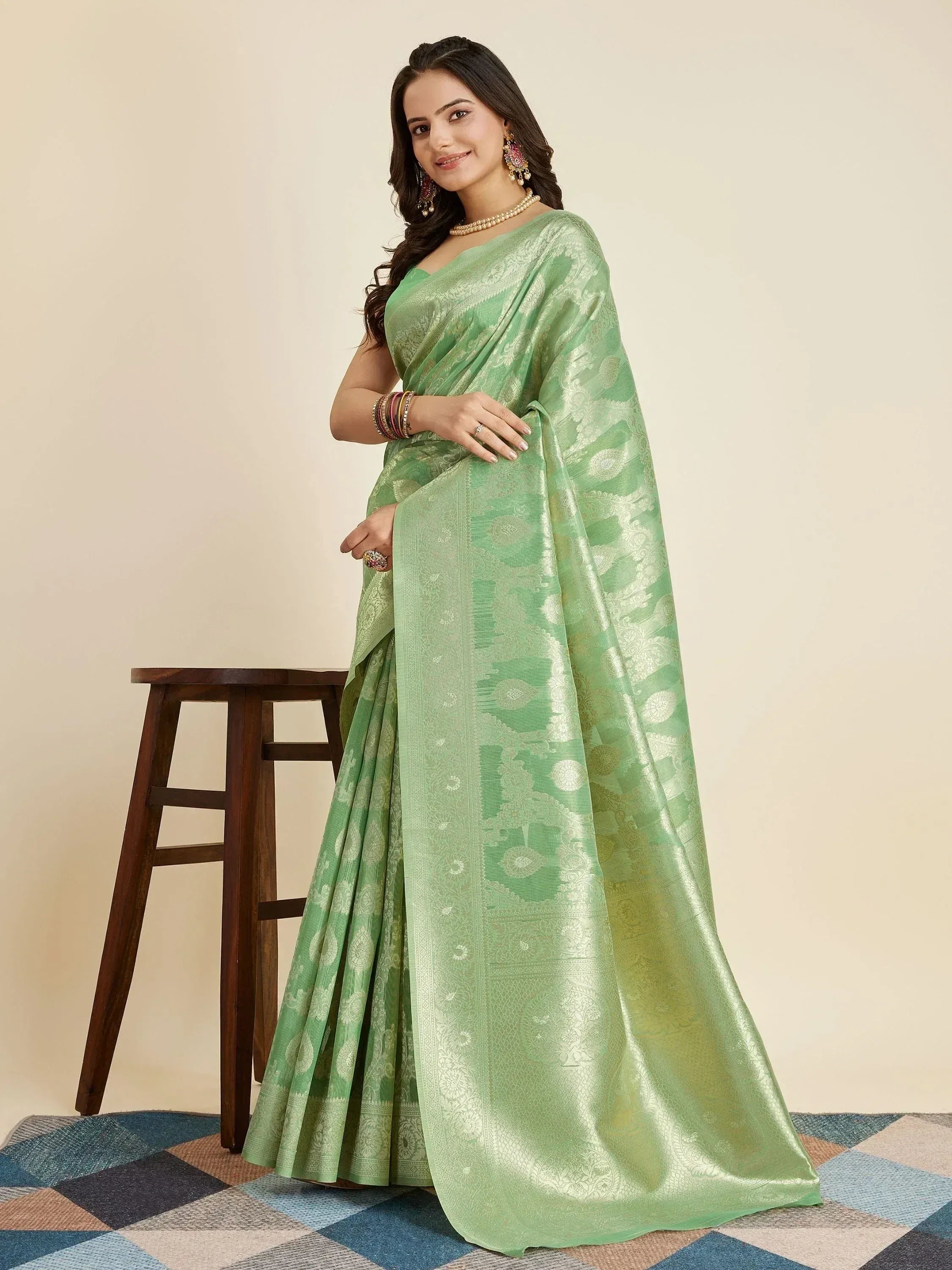 Woman in elegant mint green designer saree with gold paisley weave, perfect for Indian ethnic occasions.