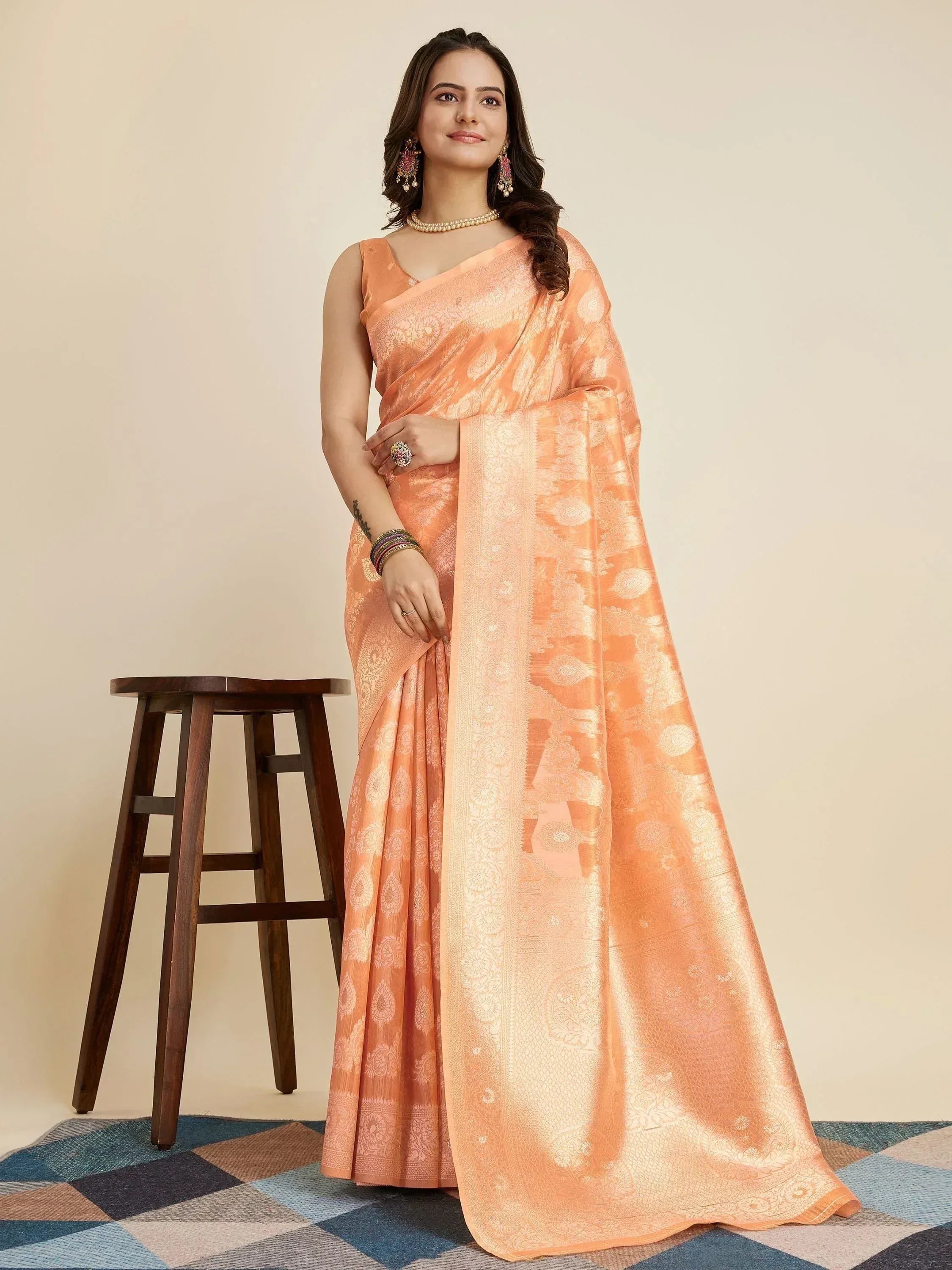 Peach designer saree with gold floral motifs, perfect for Indian ethnic wear occasions