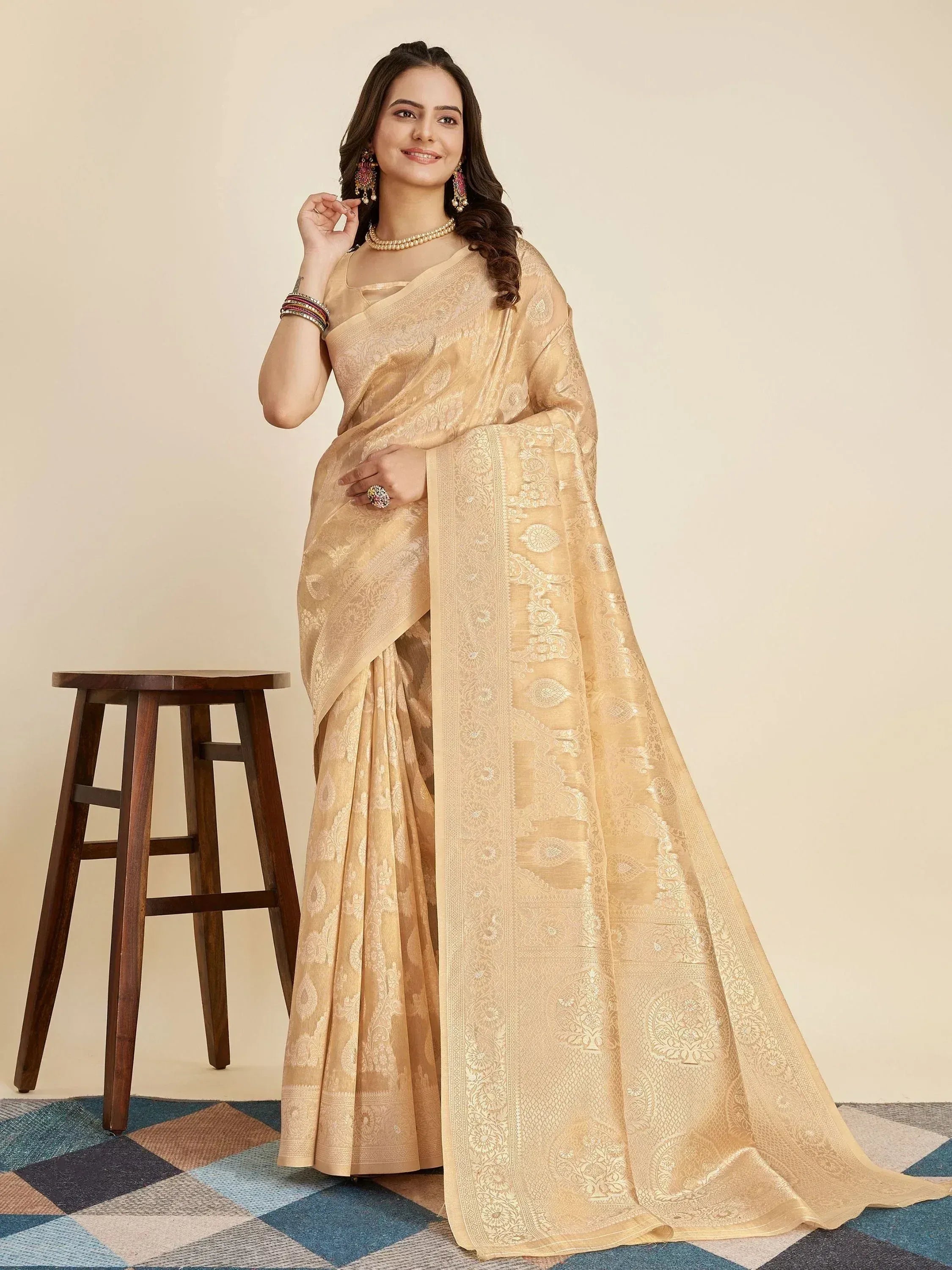 Elegant beige designer saree with intricate gold paisley weave, perfect for Indian ethnic occasions.
