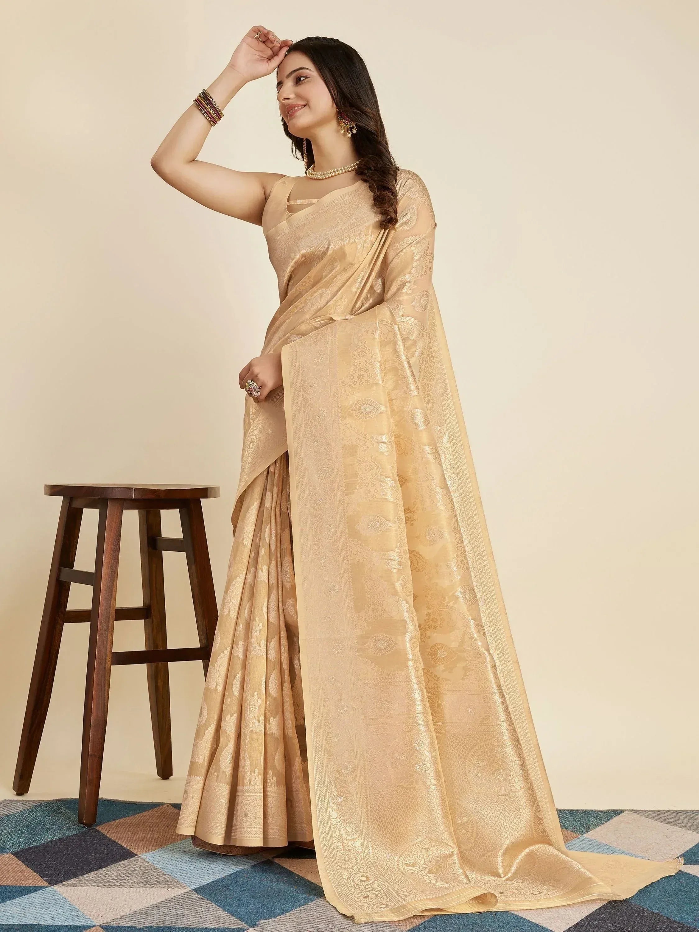 Elegant beige designer saree with intricate gold paisley weave, perfect for Indian ethnic occasions.