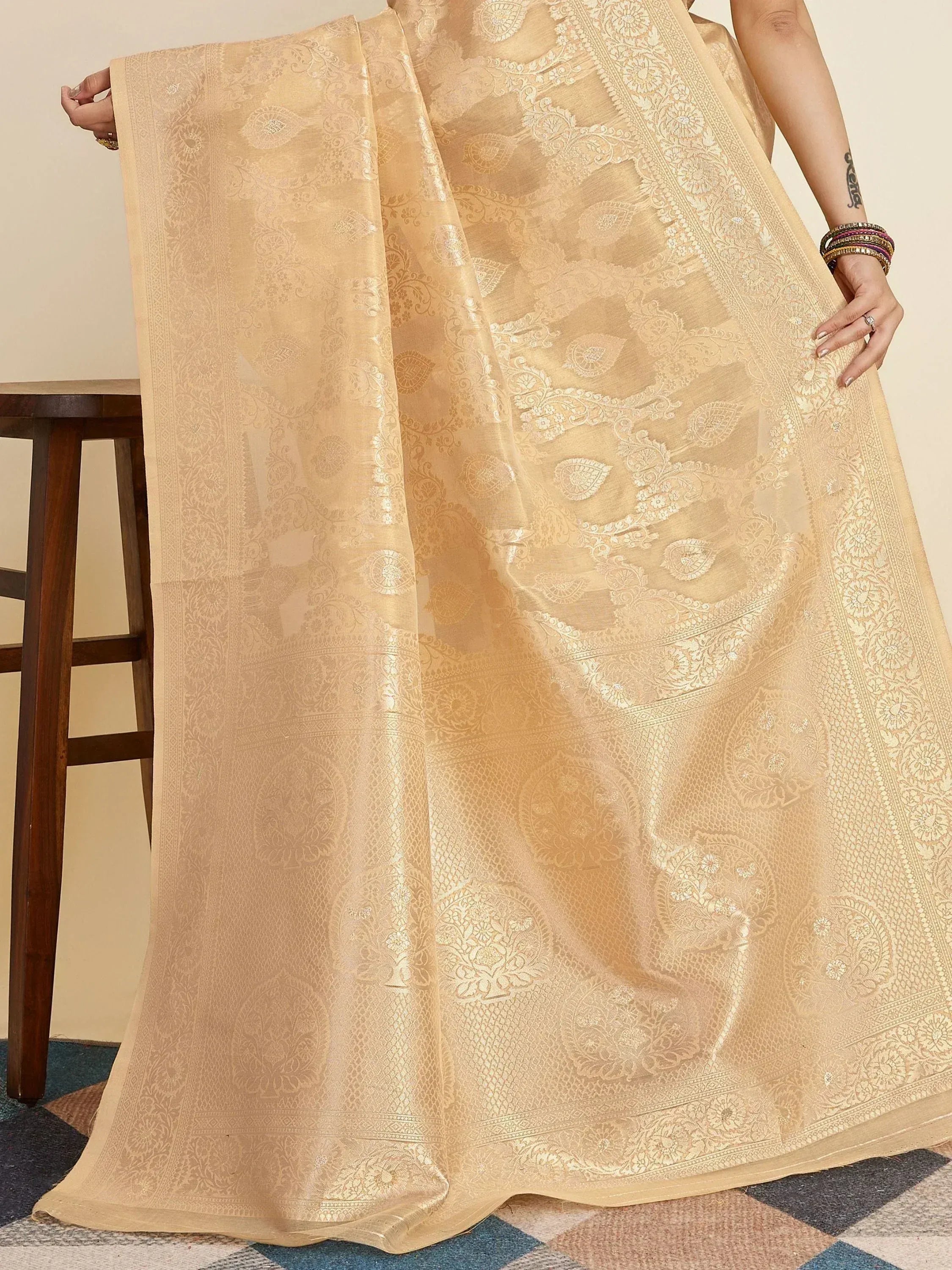 Elegant beige designer saree with intricate gold floral and paisley jacquard weave, perfect for ethnic occasions