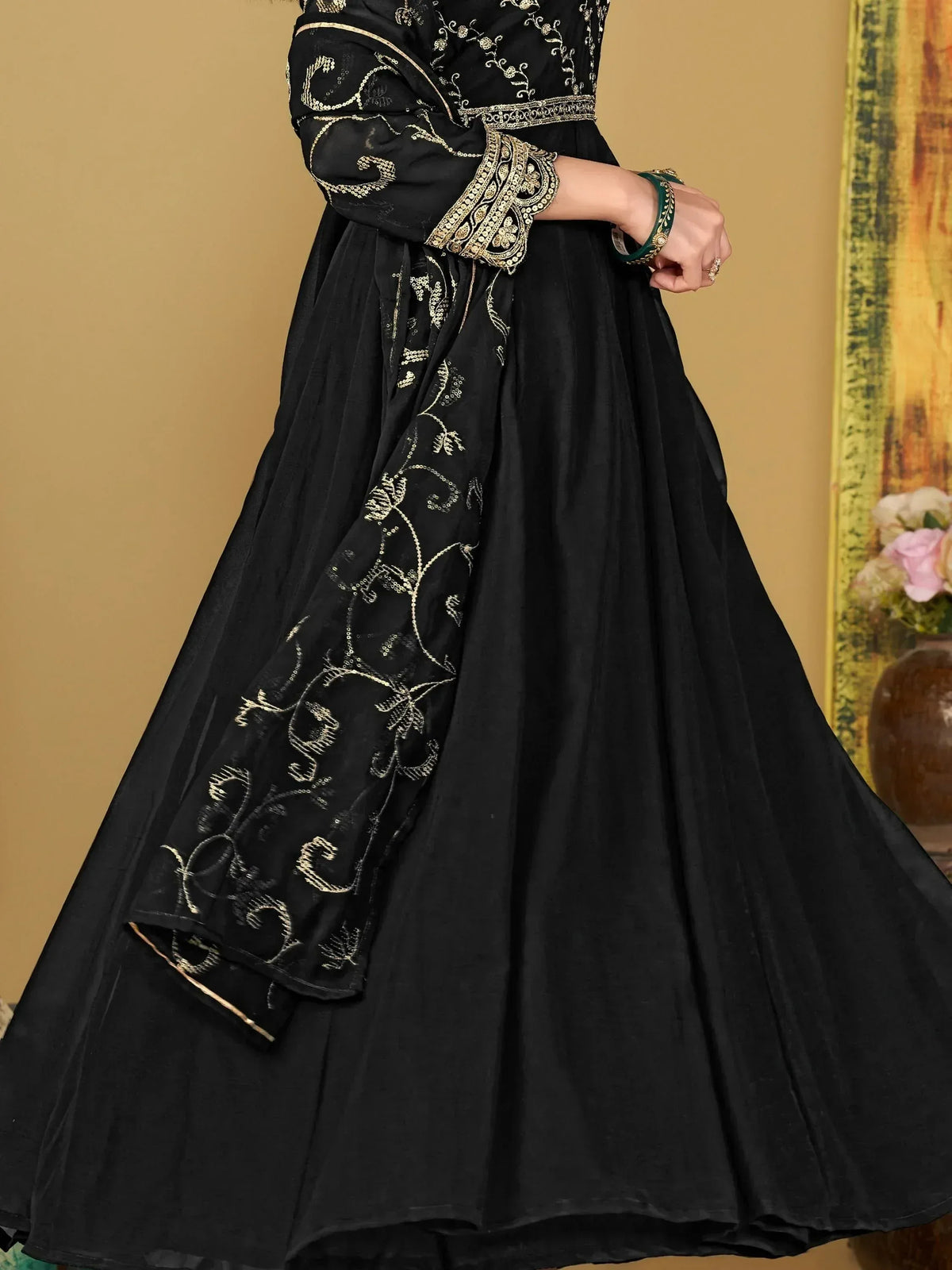 Black ethnic gown with gold embroidery and flared skirt, perfect for Indian occasions