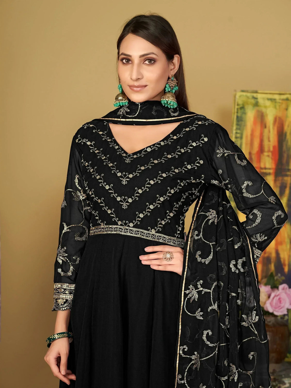 Black embroidered ethnic gown with gold detailing and matching dupatta, styled with green jewelry