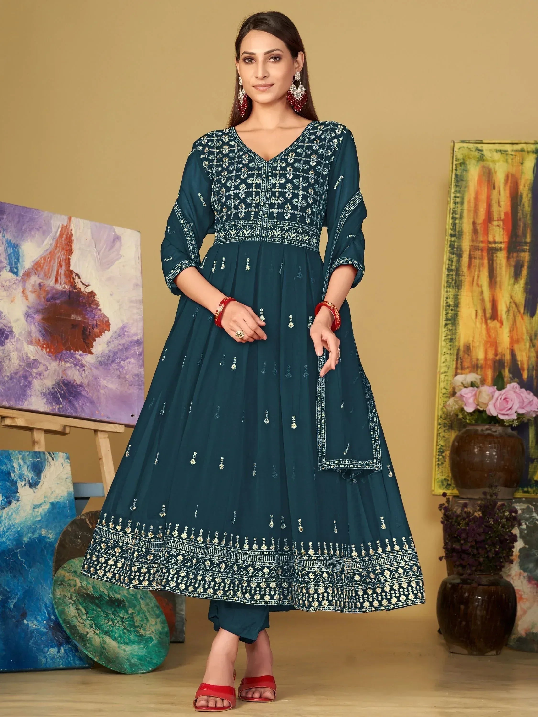 Teal embroidered anarkali suit with intricate detailing and red accessories