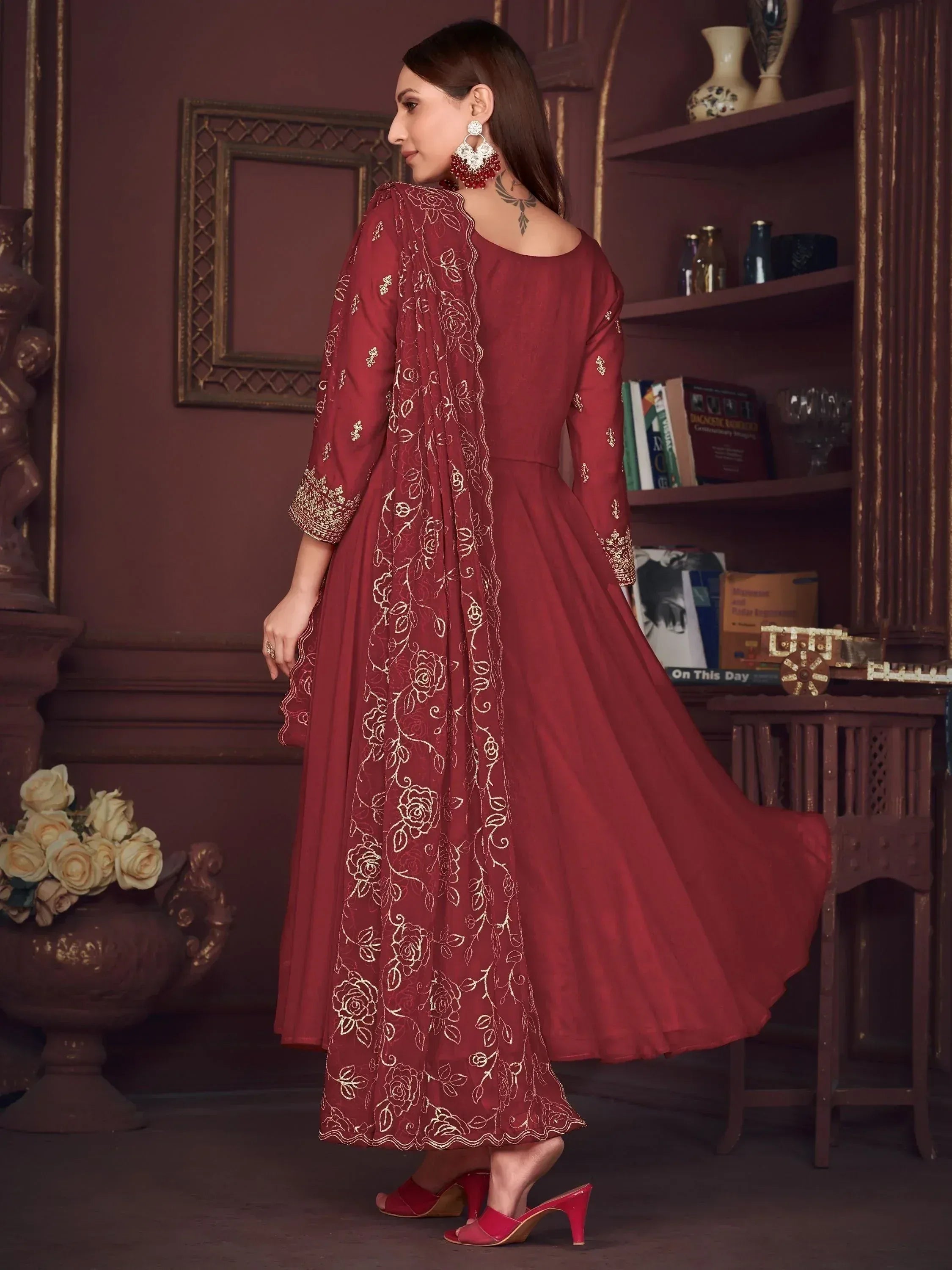 Maroon ethnic gown with gold floral embroidery, perfect for Indian weddings or festive occasions.