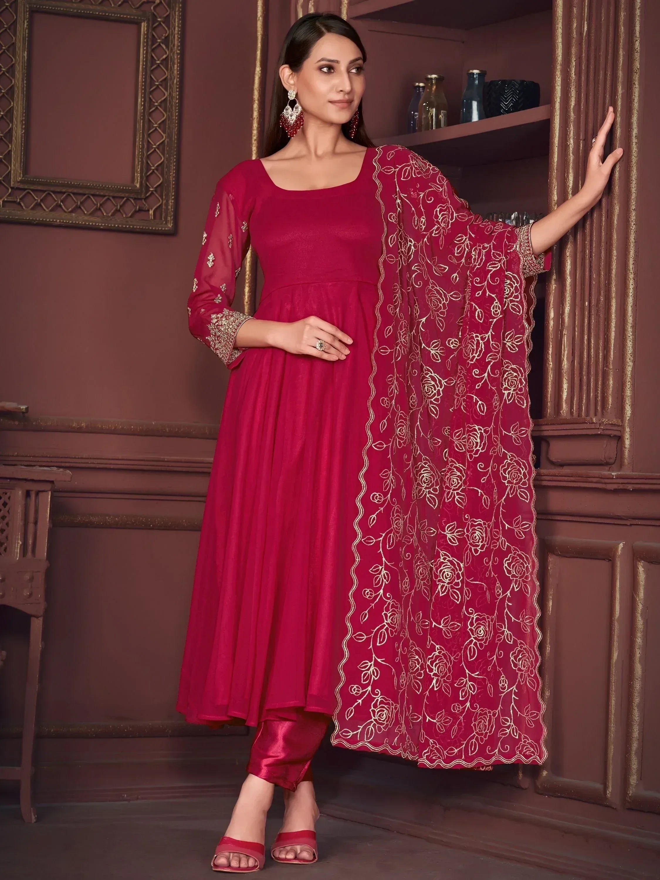Red ethnic anarkali suit with gold floral embroidery, paired with matching dupatta and pants for festive occasions