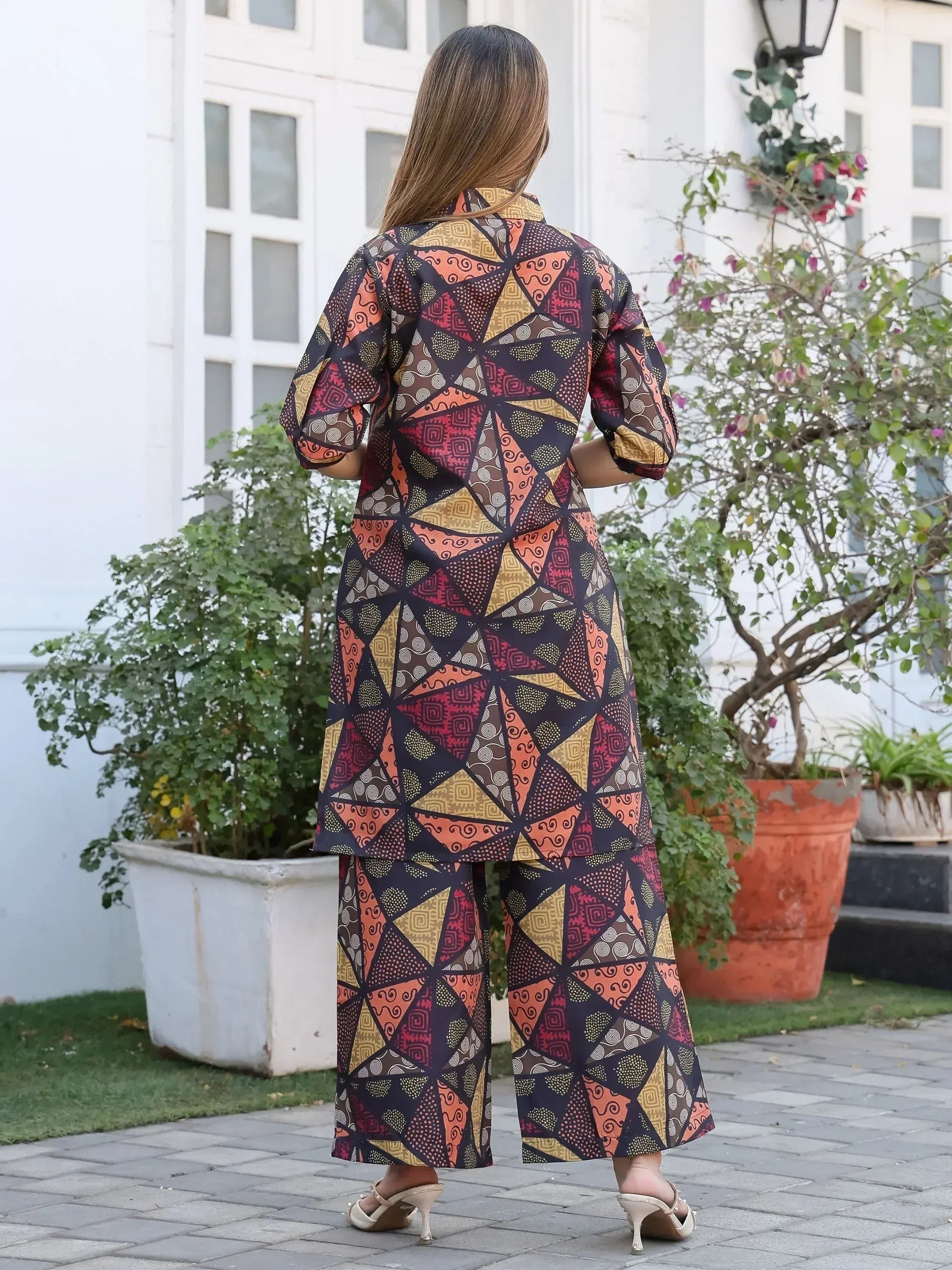 Woman in colorful geometric print ethnic kurta set with wide pants, perfect for Indian festive wear