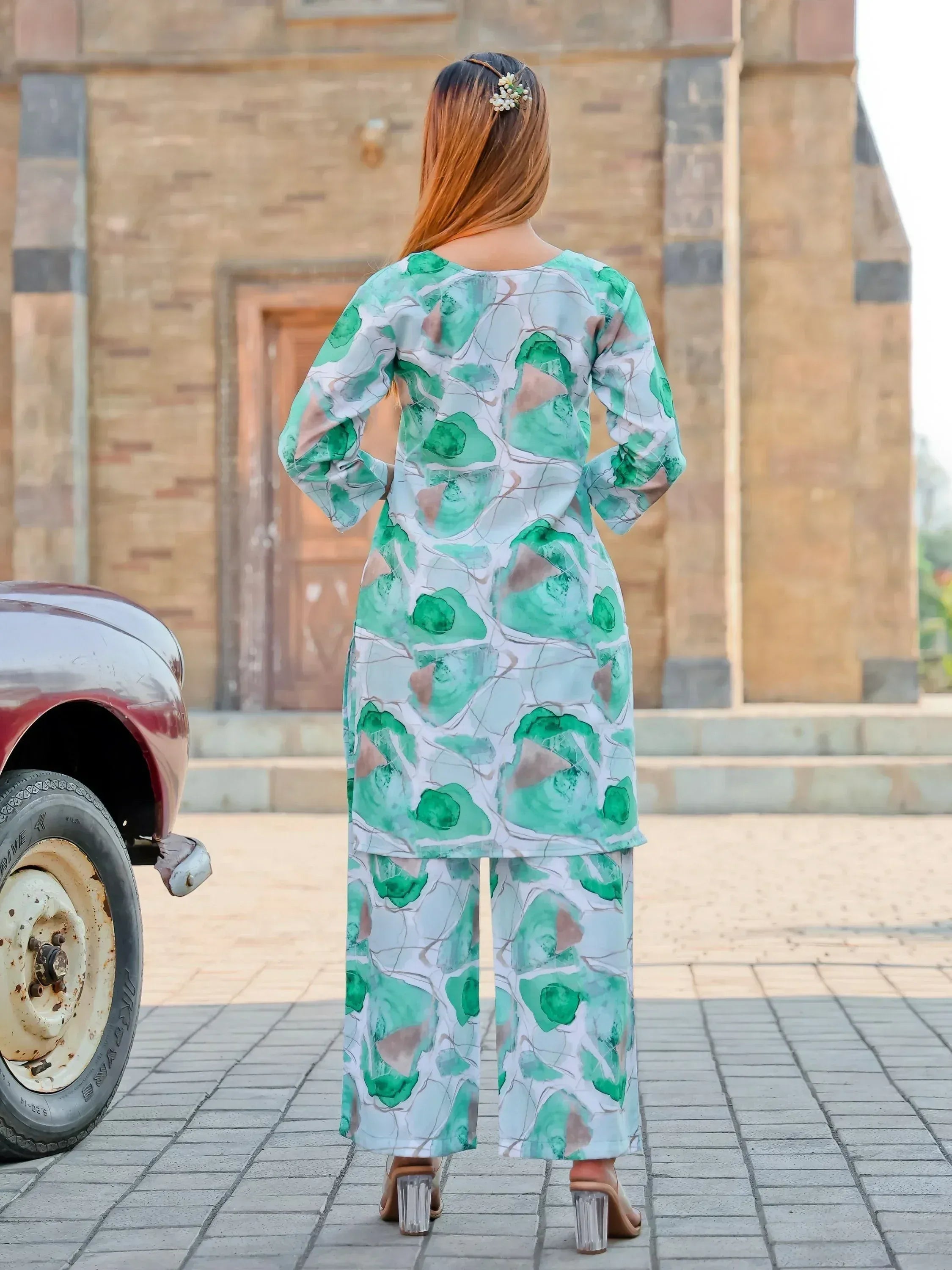 Woman wearing green and white printed kurta with palazzo pants, outdoor setting