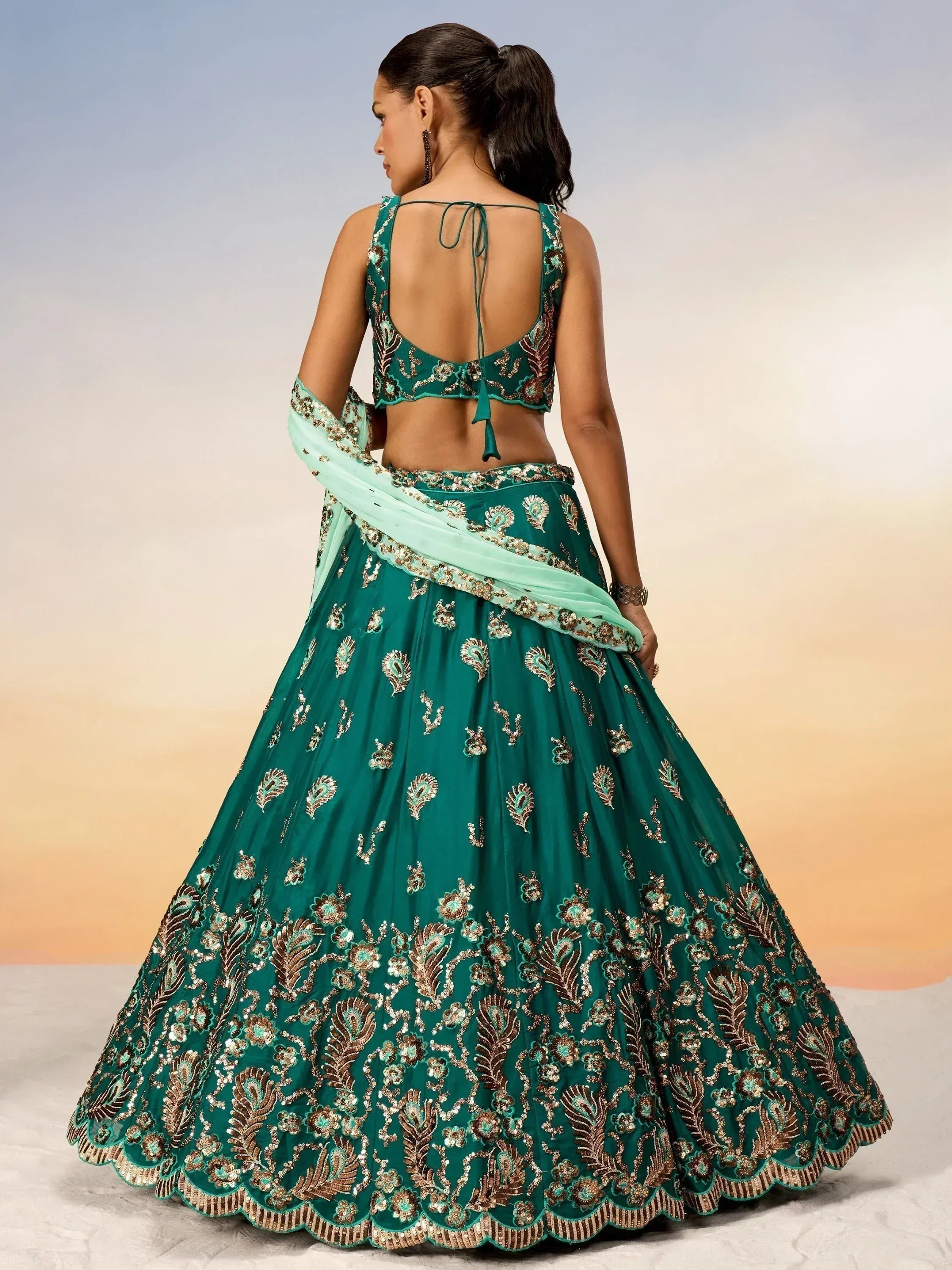 Emerald green designer lehenga choli with gold embroidery and back tie blouse, perfect for Indian weddings