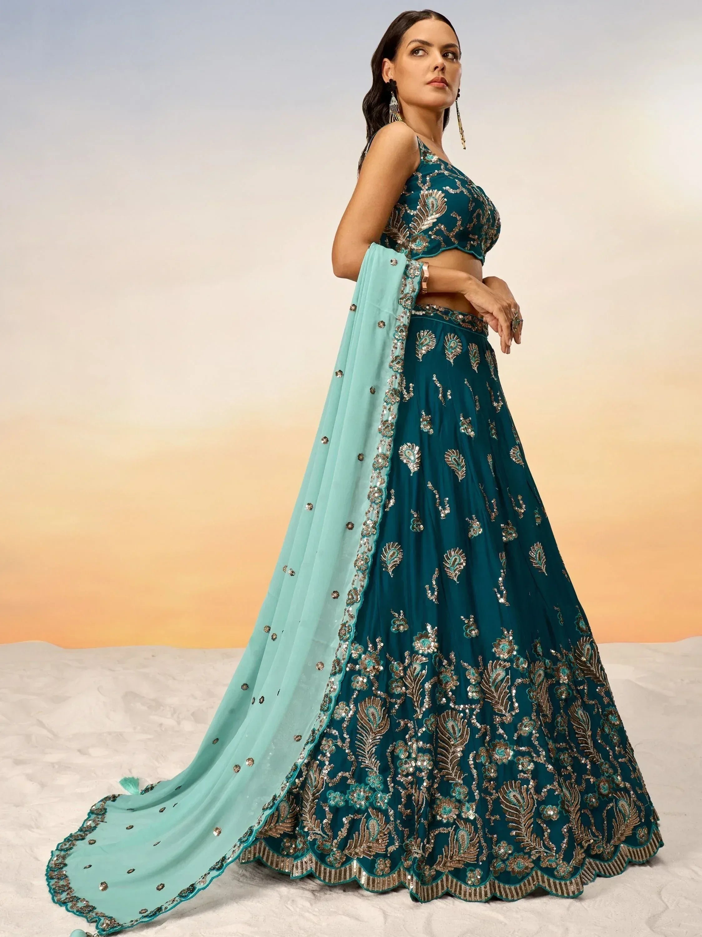 Teal designer lehenga choli with gold embroidery and matching dupatta, perfect for Indian ethnic wear occasions.