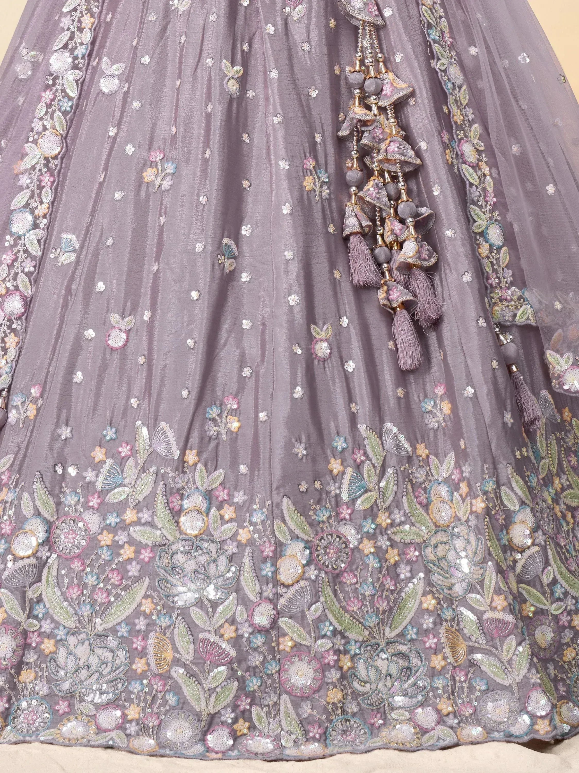 Grey floral embroidered lehenga with tassels, perfect for Indian ethnic wear occasions.