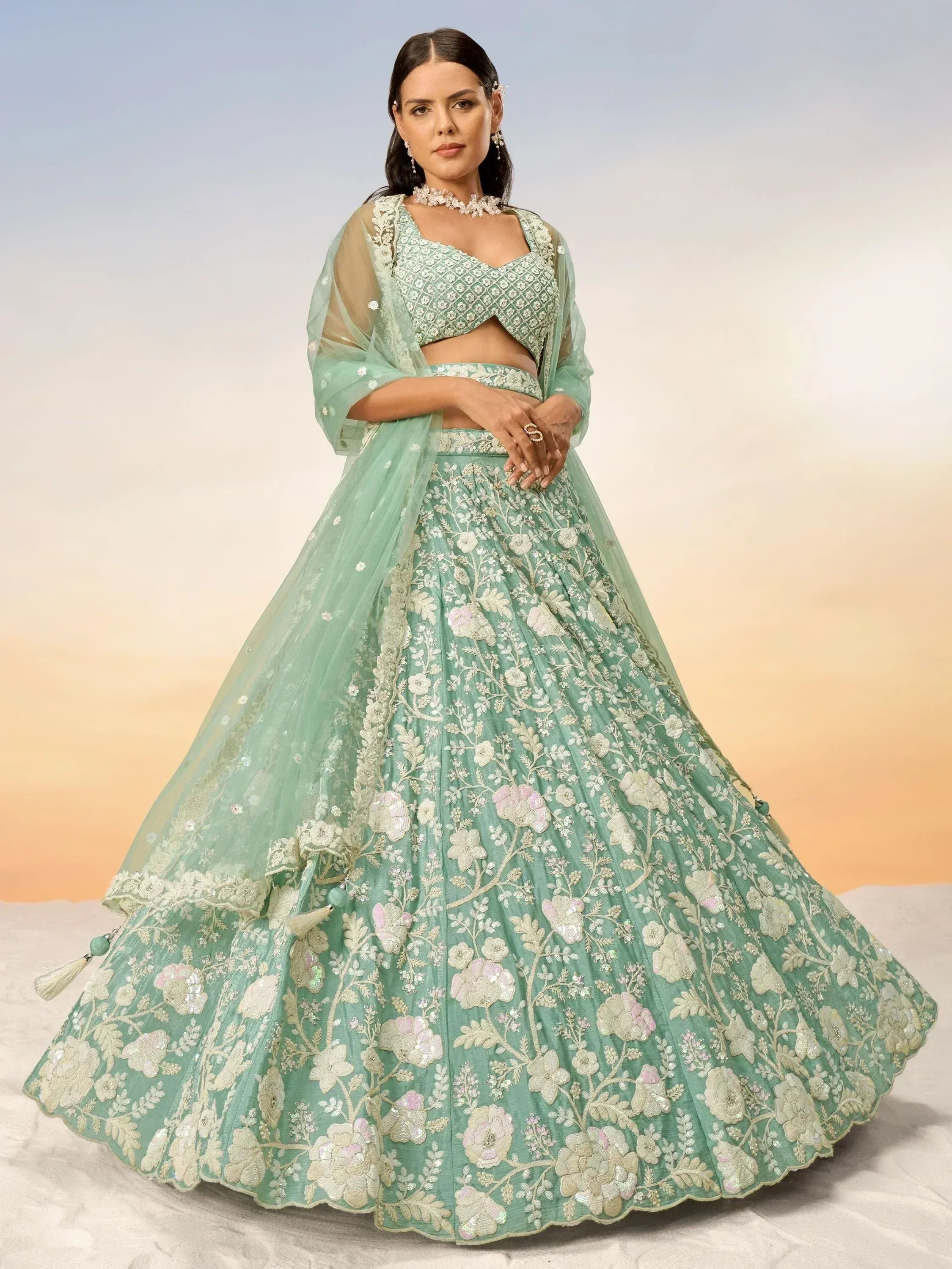 Mint green designer lehenga choli with floral embroidery and sheer dupatta, perfect for Indian weddings and festive occasions.