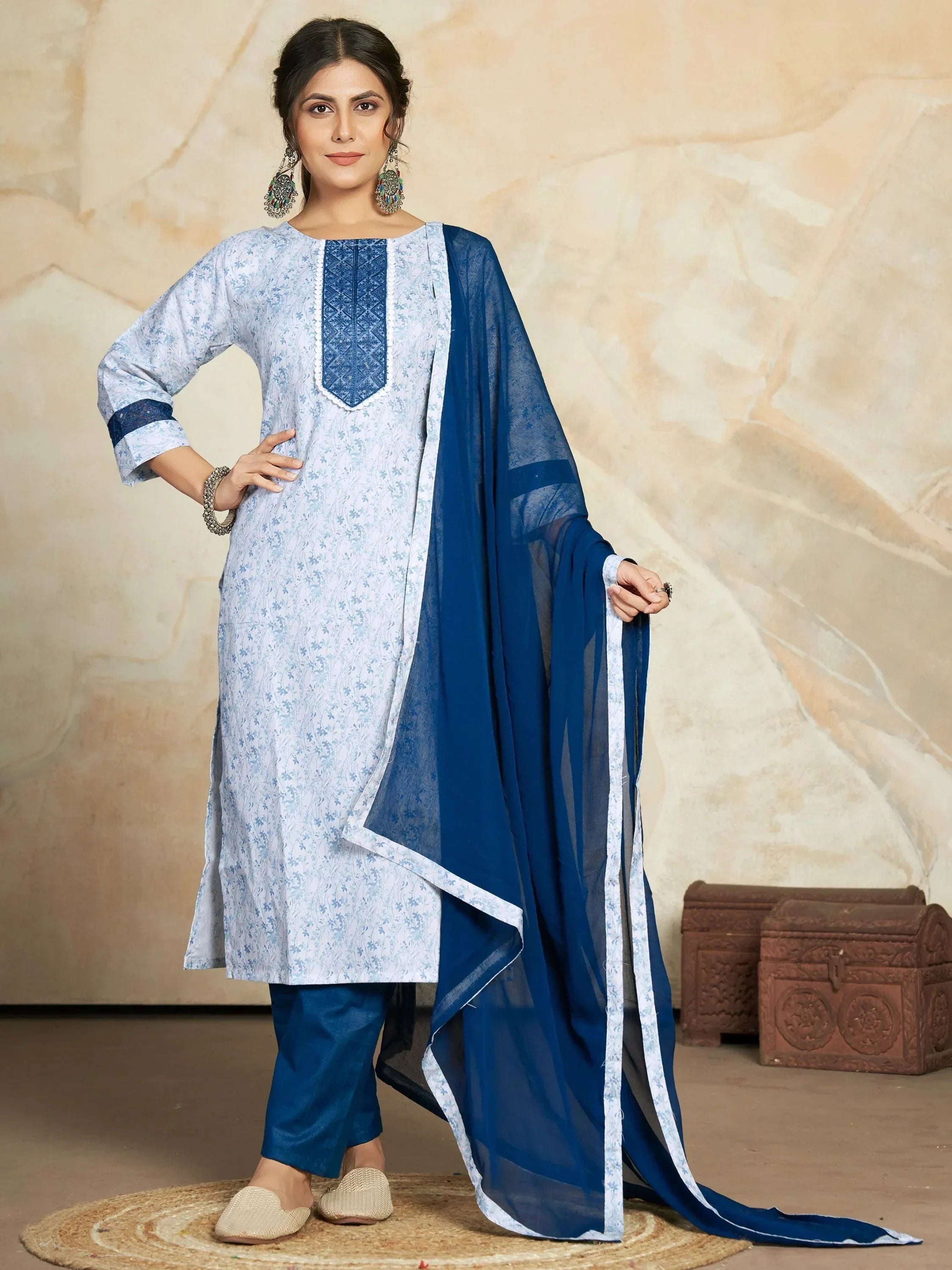 Woman in blue floral printed salwar kameez with matching dupatta and statement earrings