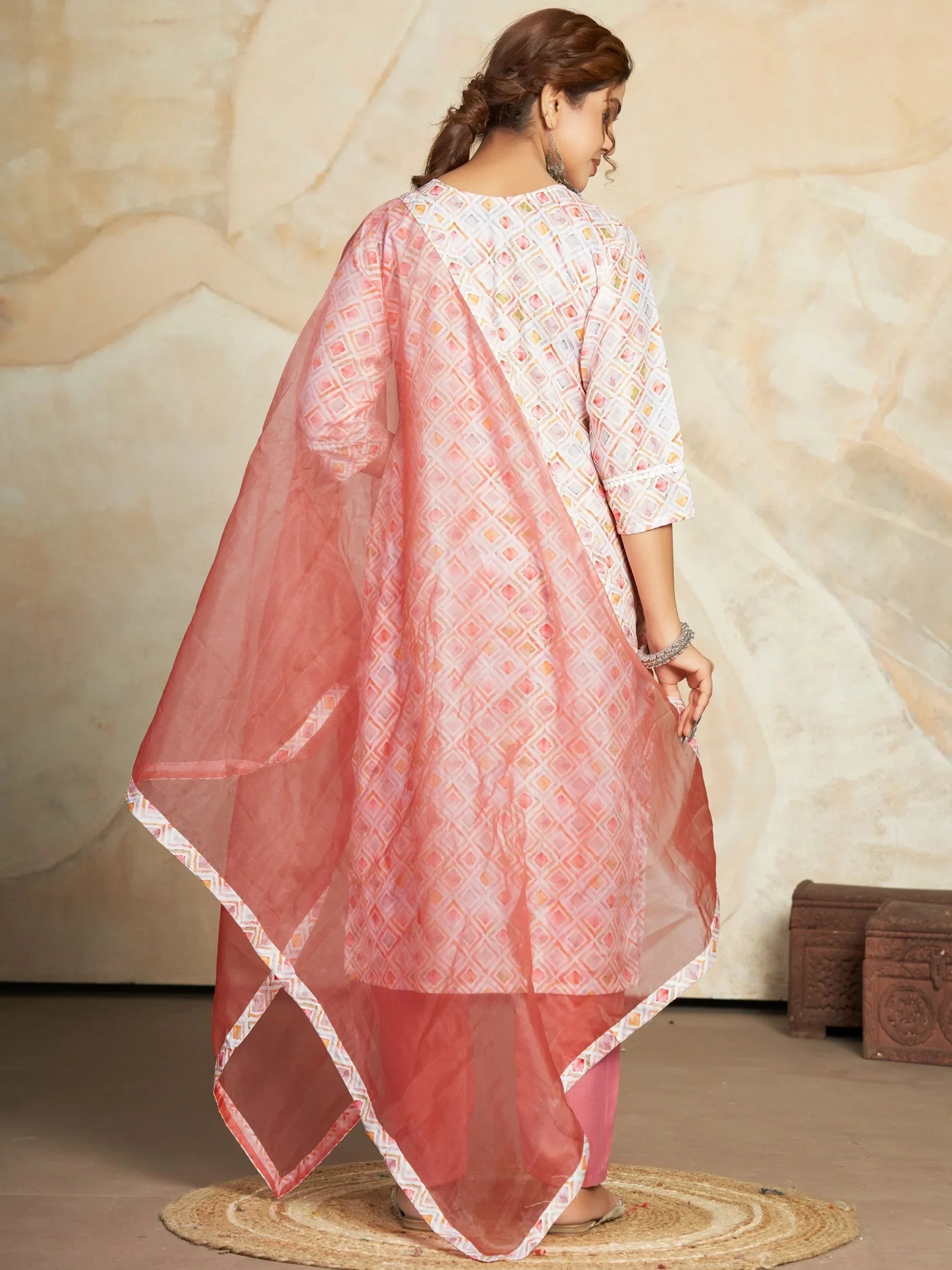 Woman in printed pink ethnic salwar kameez with sheer dupatta, back view, stylish pose