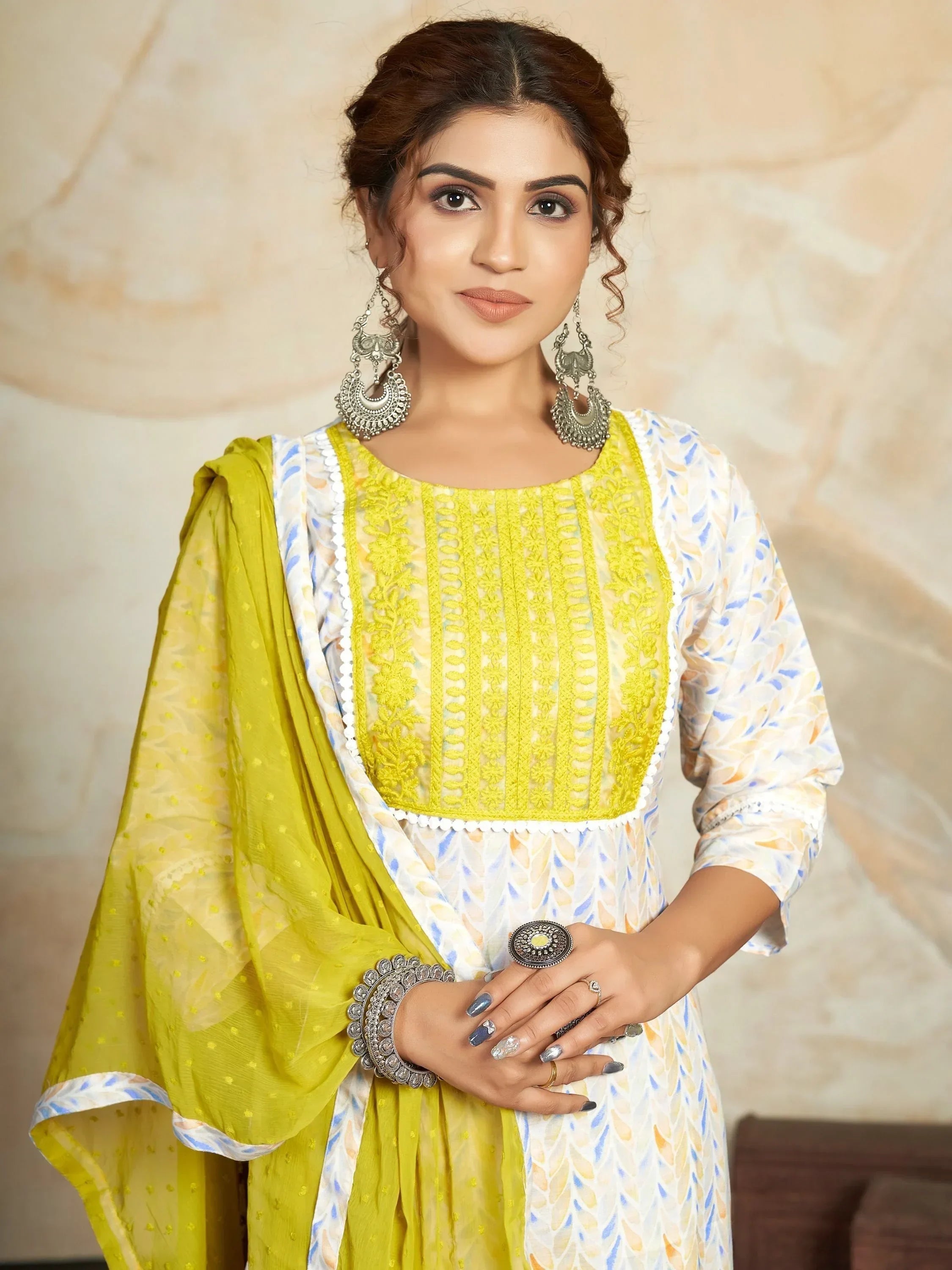 Woman in yellow and white embroidered salwar kameez with dupatta, wearing silver jewelry