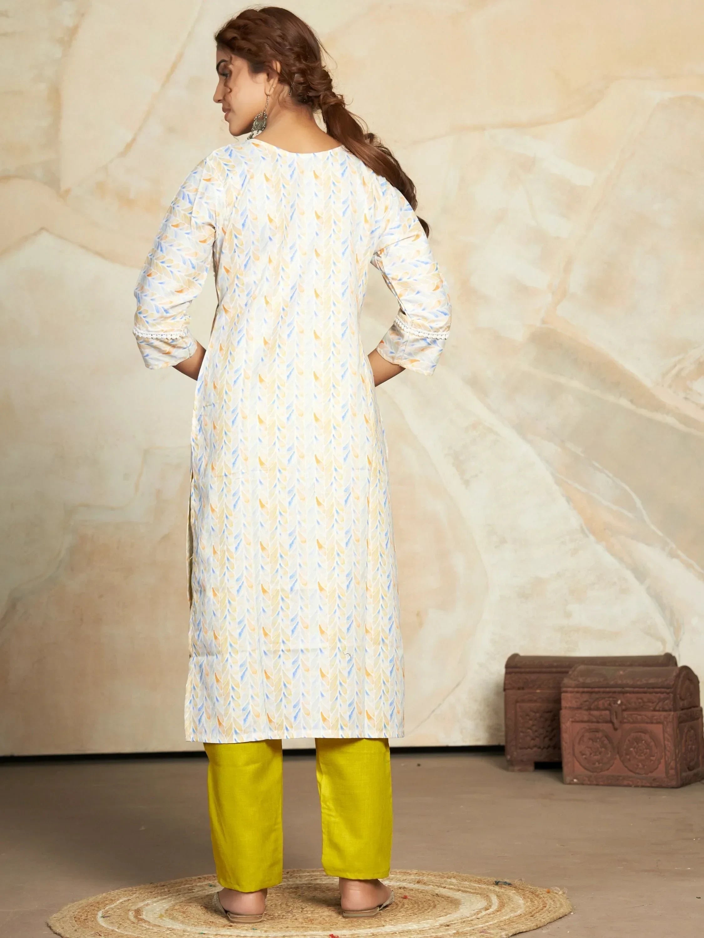 Woman in printed cotton kurti with yellow pants, standing indoors, back facing camera
