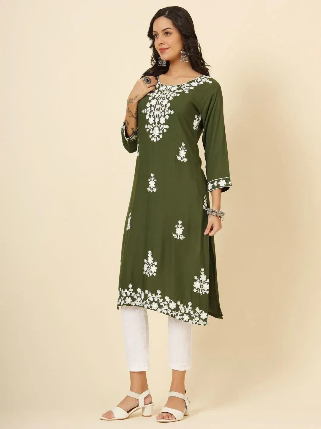 Woman wearing olive green kurti with white floral embroidery and white pants
