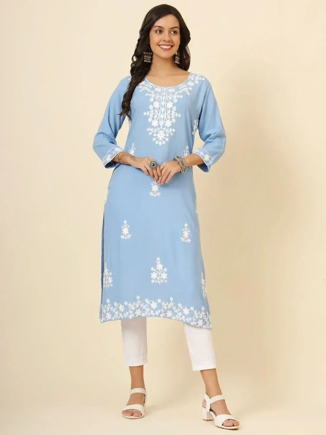 Light blue embroidered kurta with white floral patterns, paired with white pants and sandals