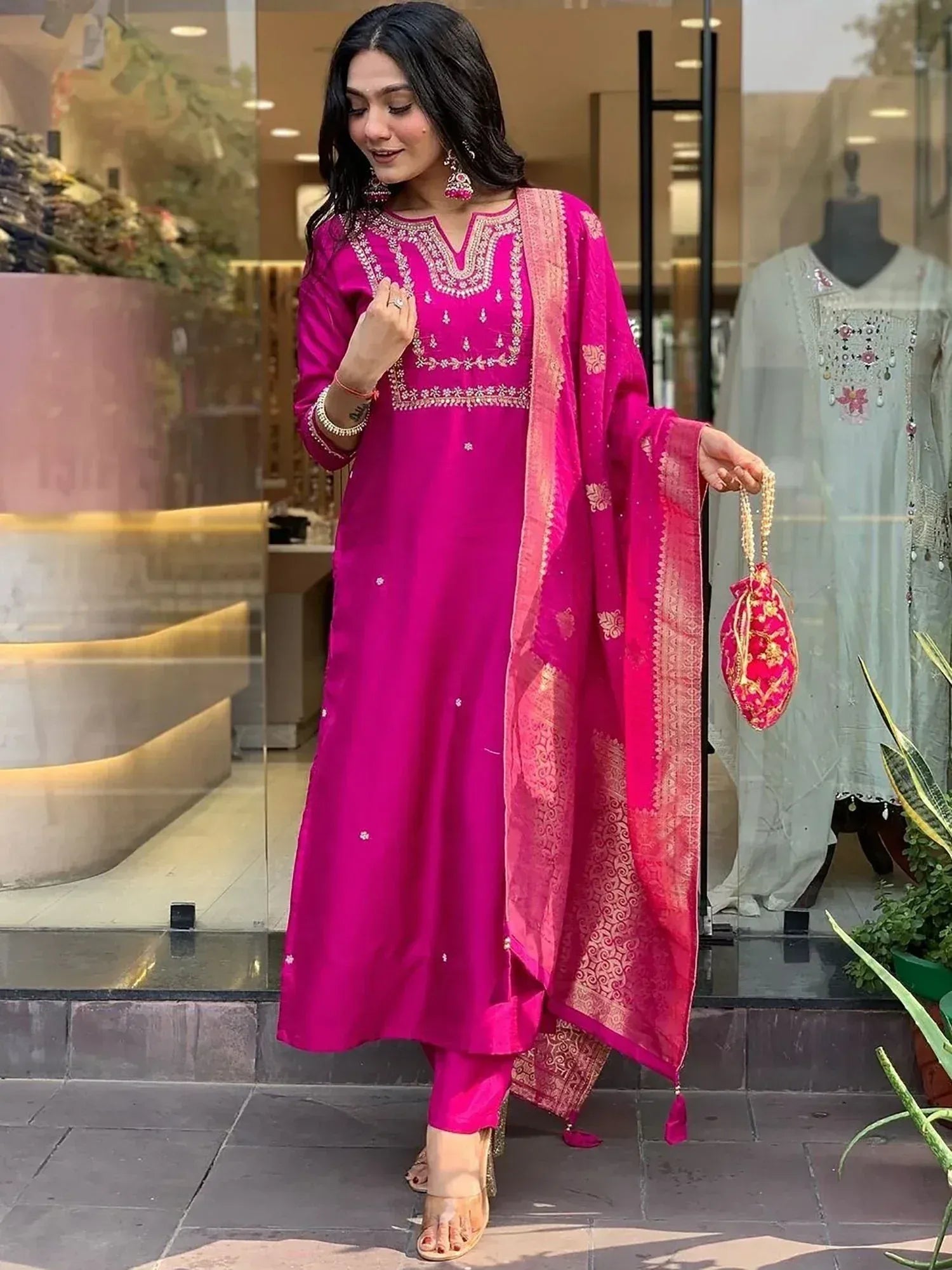 Vibrant pink ethnic salwar kameez with gold embroidery and matching dupatta, perfect for festive occasions.