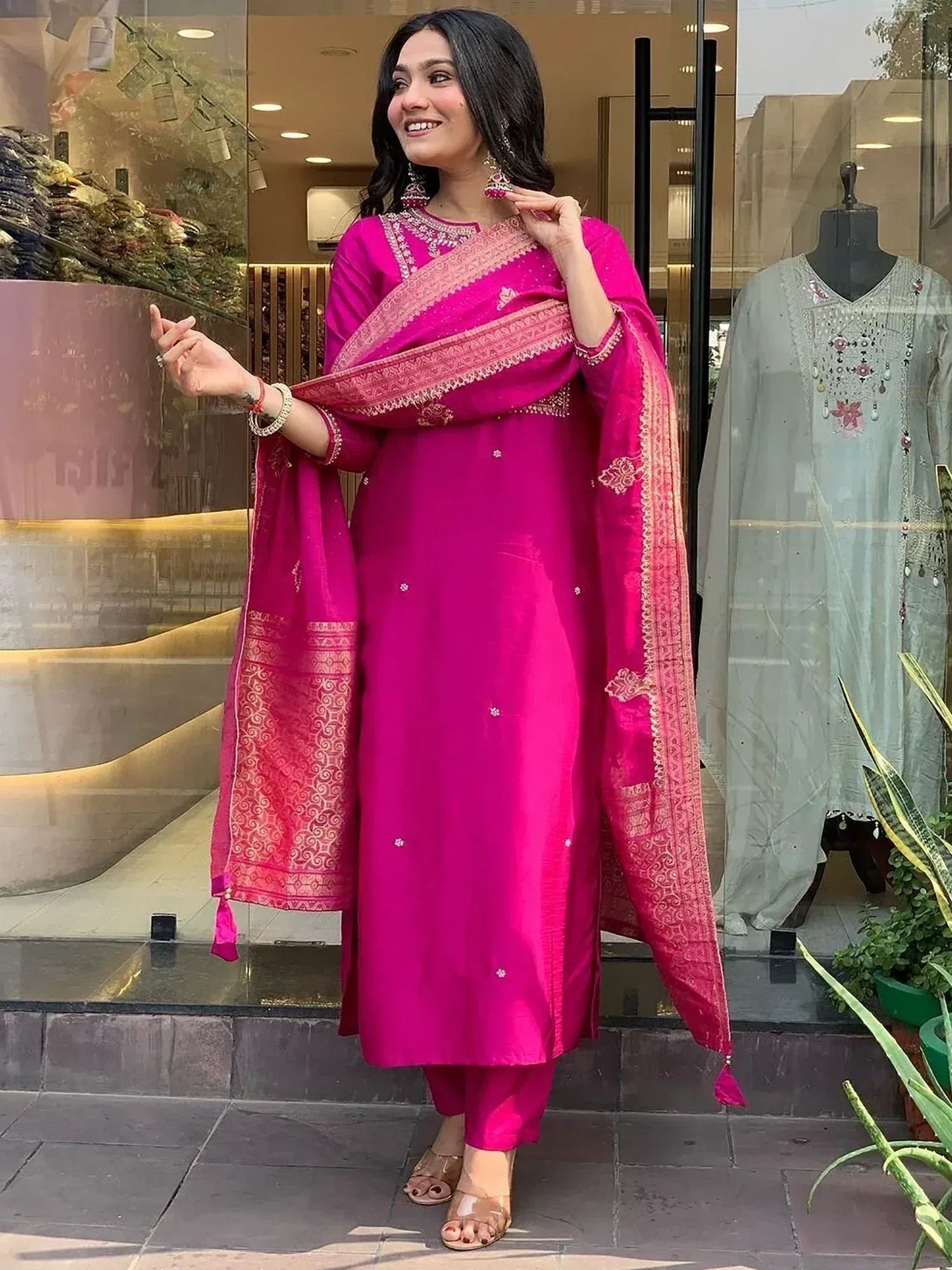 Woman in vibrant pink ethnic salwar kameez with embroidered dupatta, perfect for Indian occasions