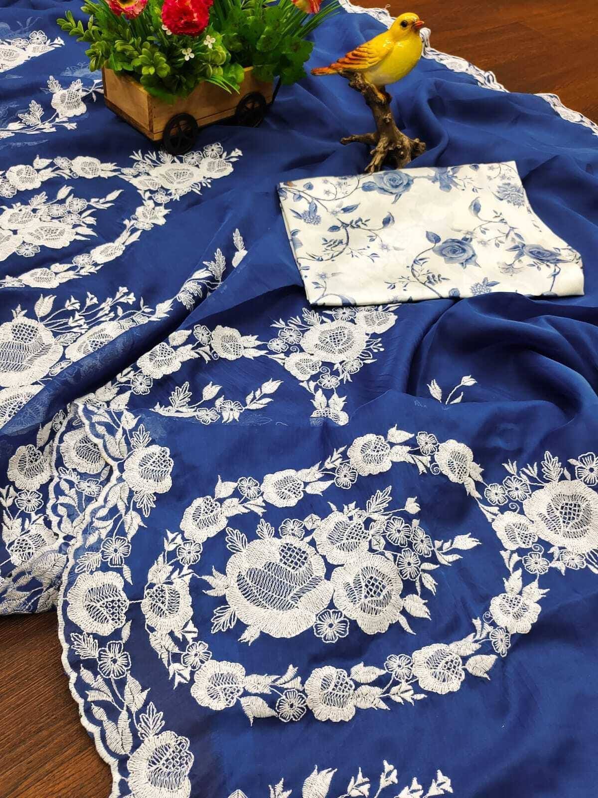 Blue ethnic saree with white floral embroidery, paired with matching blouse fabric, perfect for Indian wear.