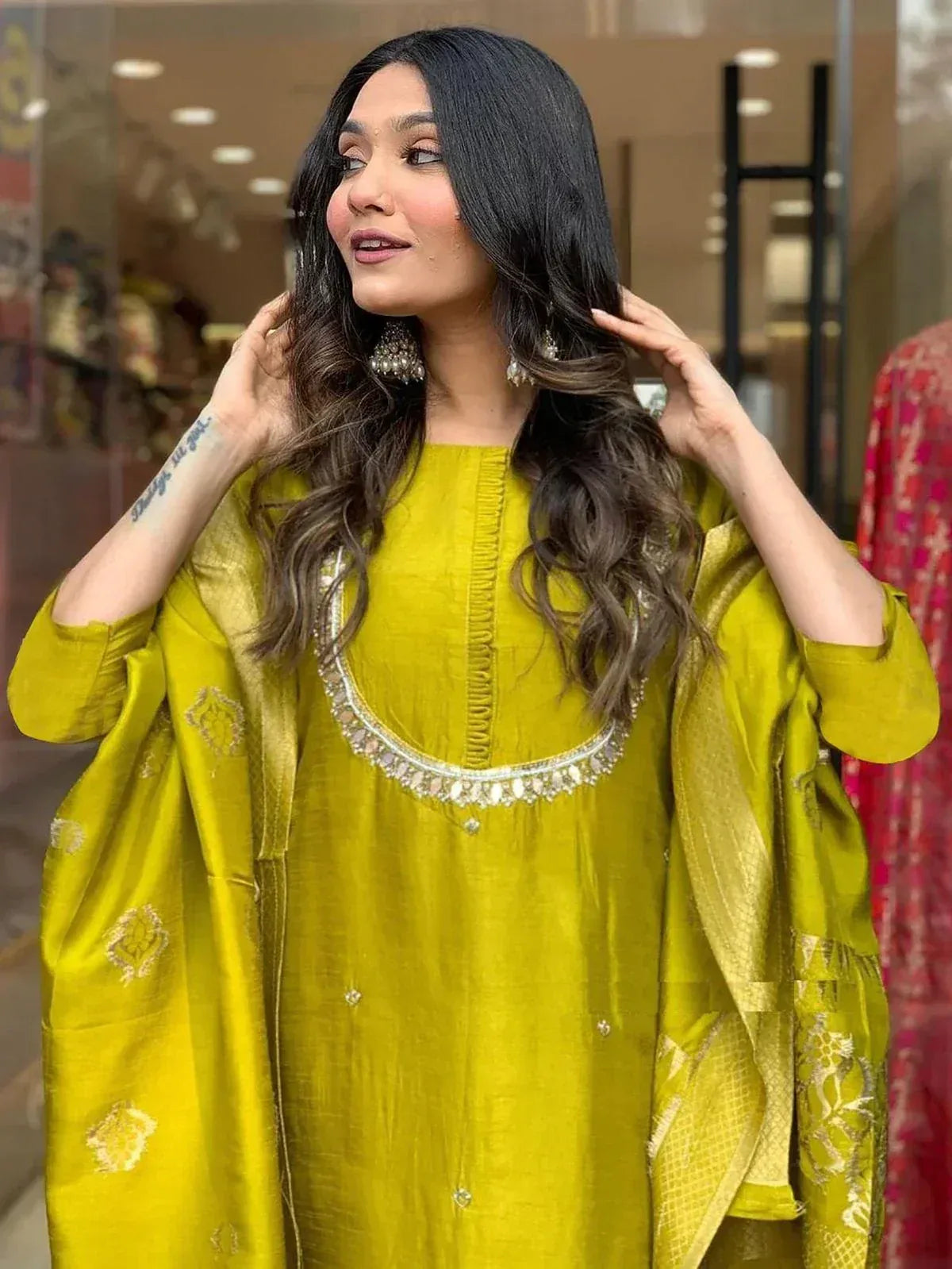 Woman in vibrant yellow ethnic kurta with mirror work, paired with matching dupatta, perfect for Indian festive occasions.