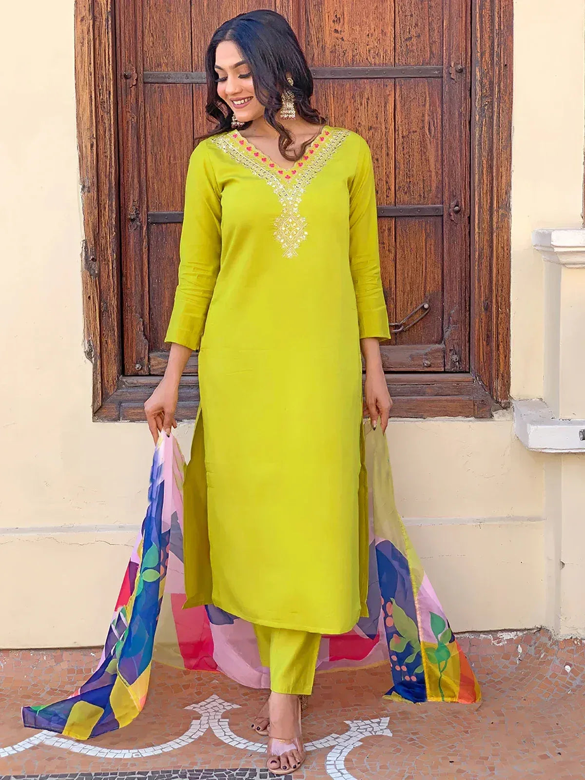 Vibrant lime green ethnic kurti with gold embroidery, paired with matching pants and colorful dupatta, perfect for Indian festive wear.