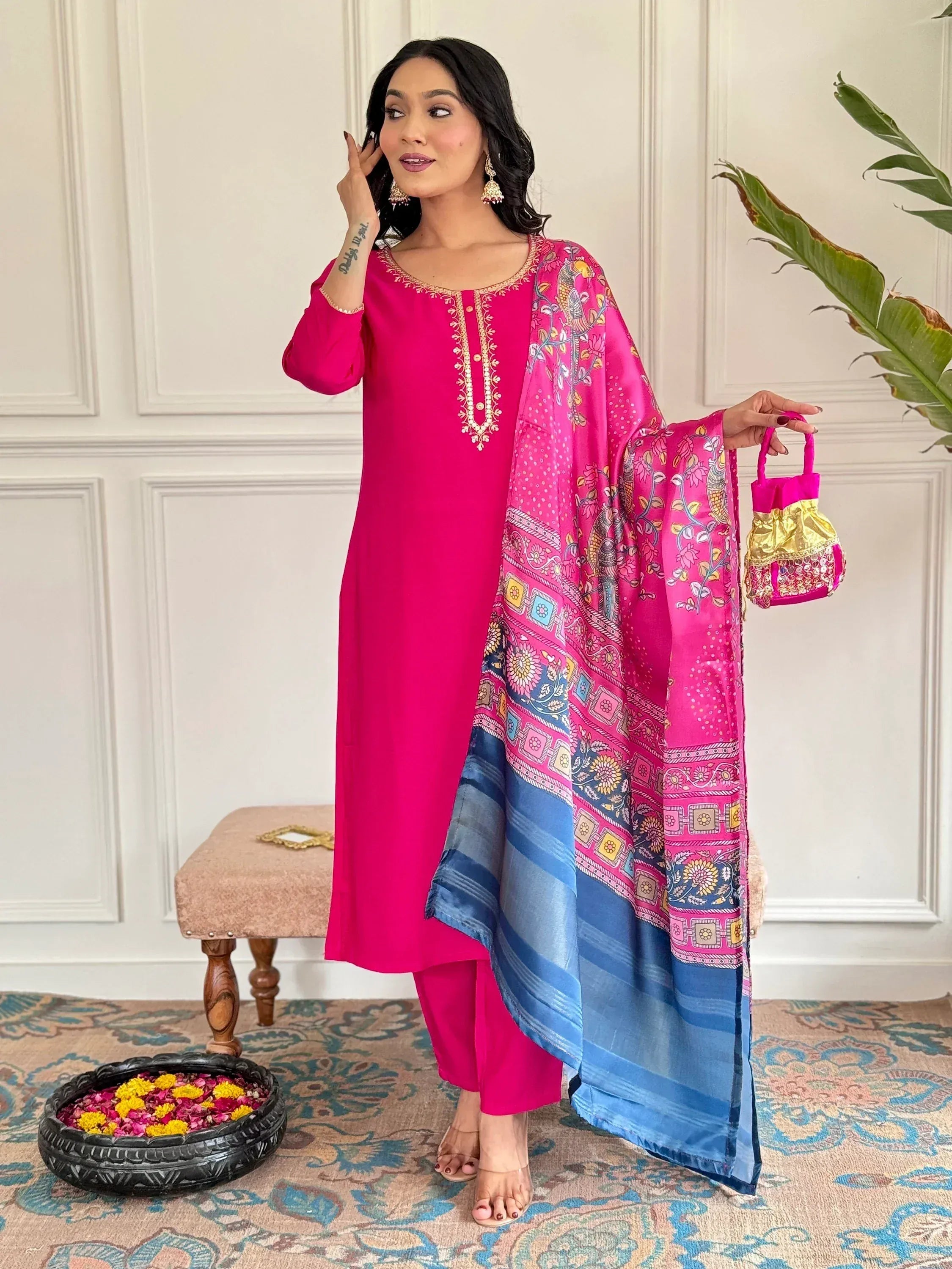 Woman in vibrant pink embroidered kurta with printed dupatta and matching potli bag, Indian ethnic wear