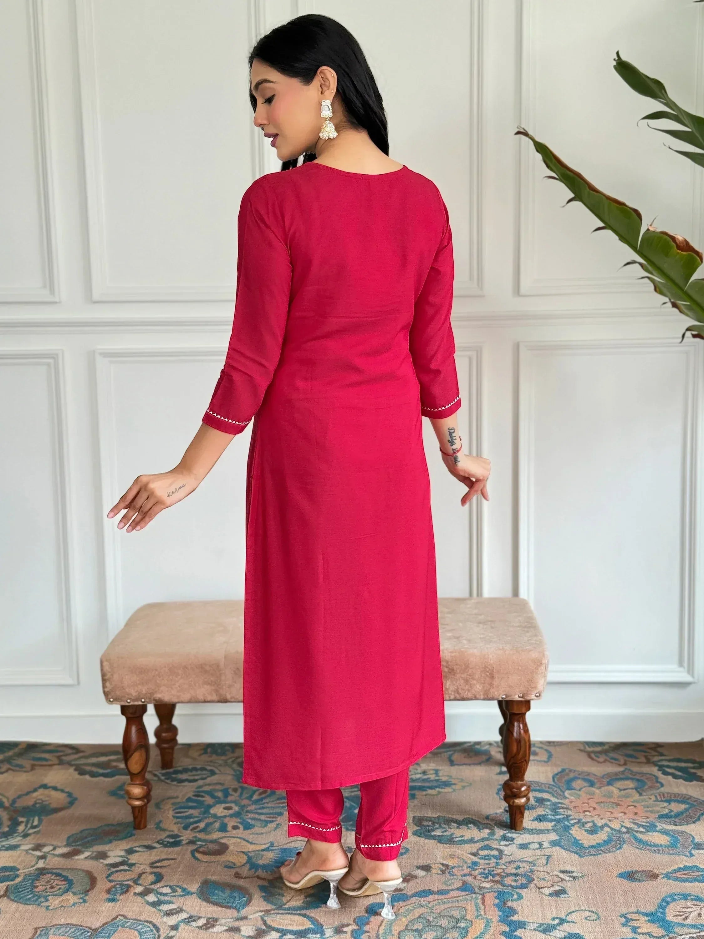 Red ethnic kurta set with white embroidery, paired with matching pants and heels for Indian wear