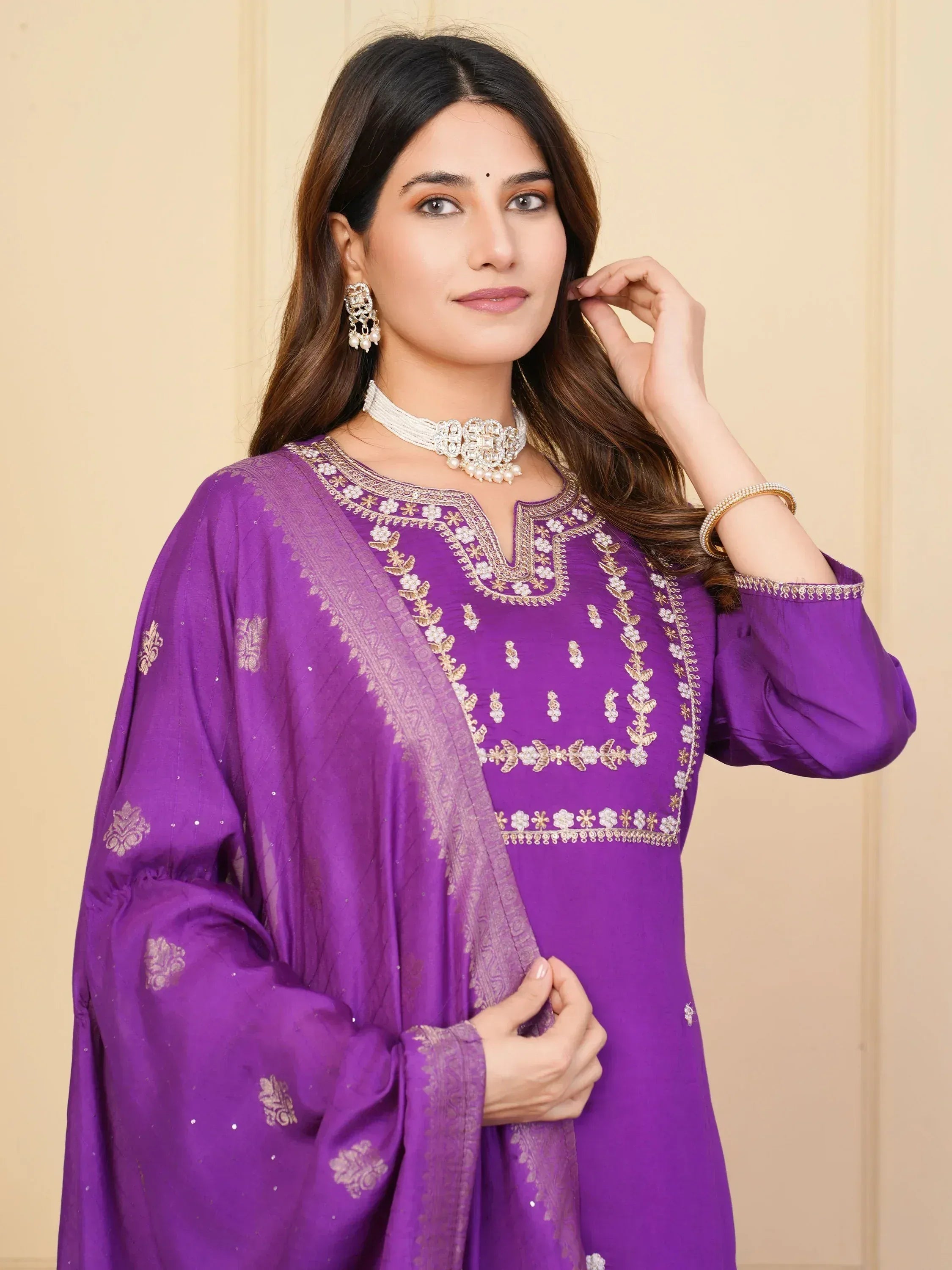 Purple embroidered ethnic salwar kameez with gold detailing and matching dupatta, styled with traditional jewelry