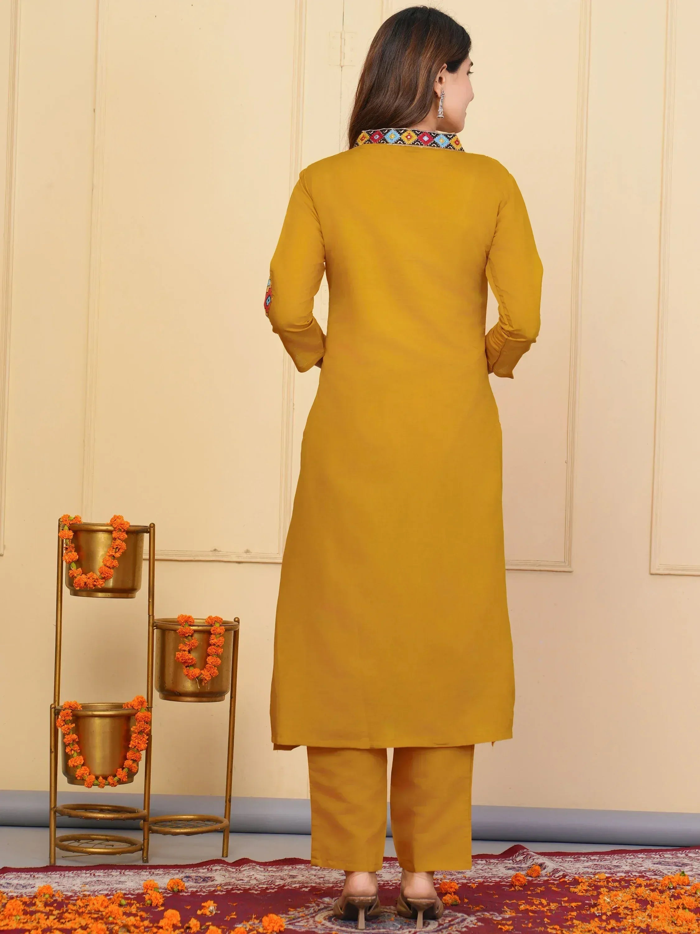 Mustard yellow ethnic kurta with colorful embroidered collar and matching pants, perfect for Indian festive wear.