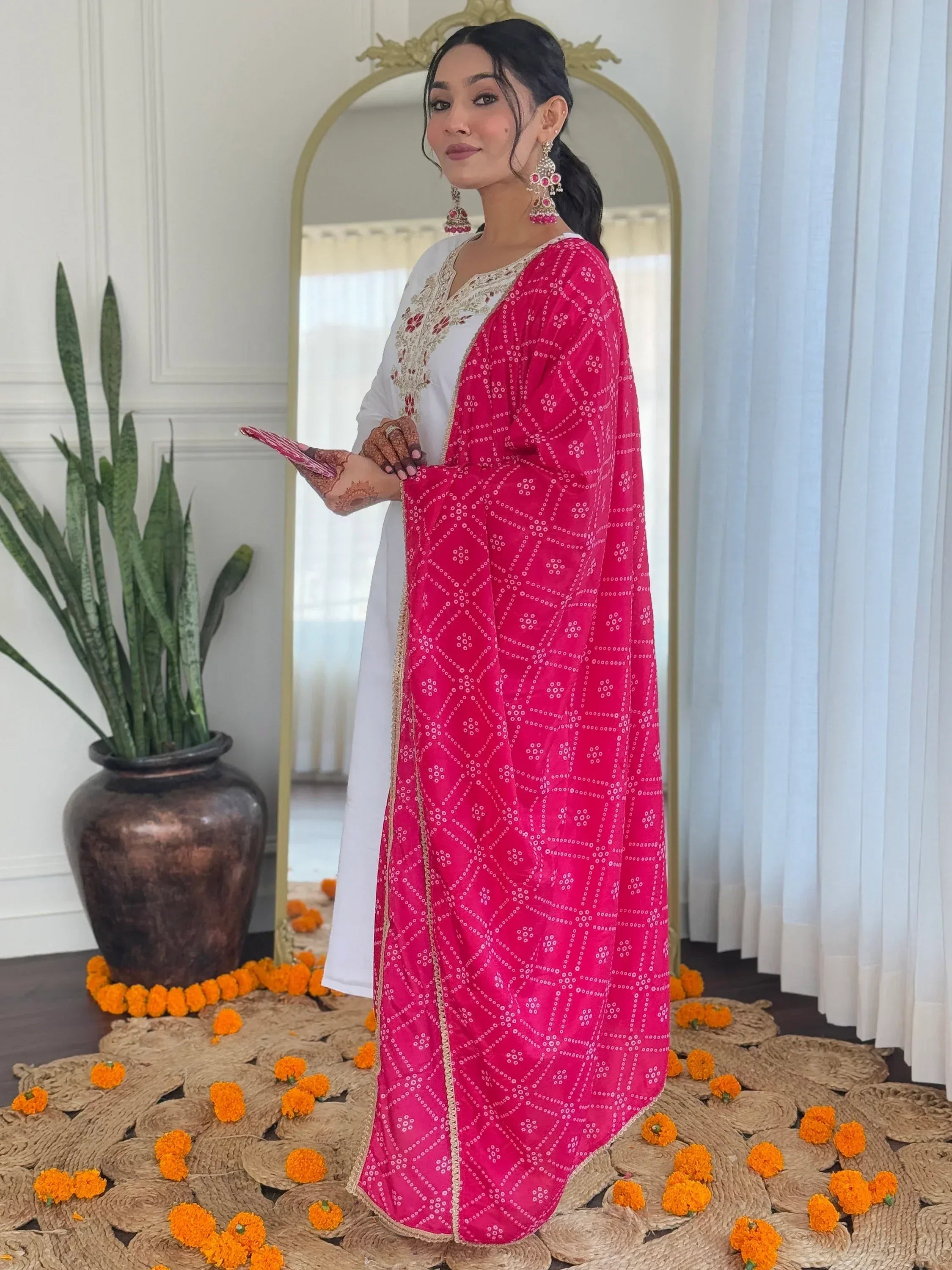 Woman in white embroidered kurta with pink bandhani dupatta, traditional Indian ethnic wear