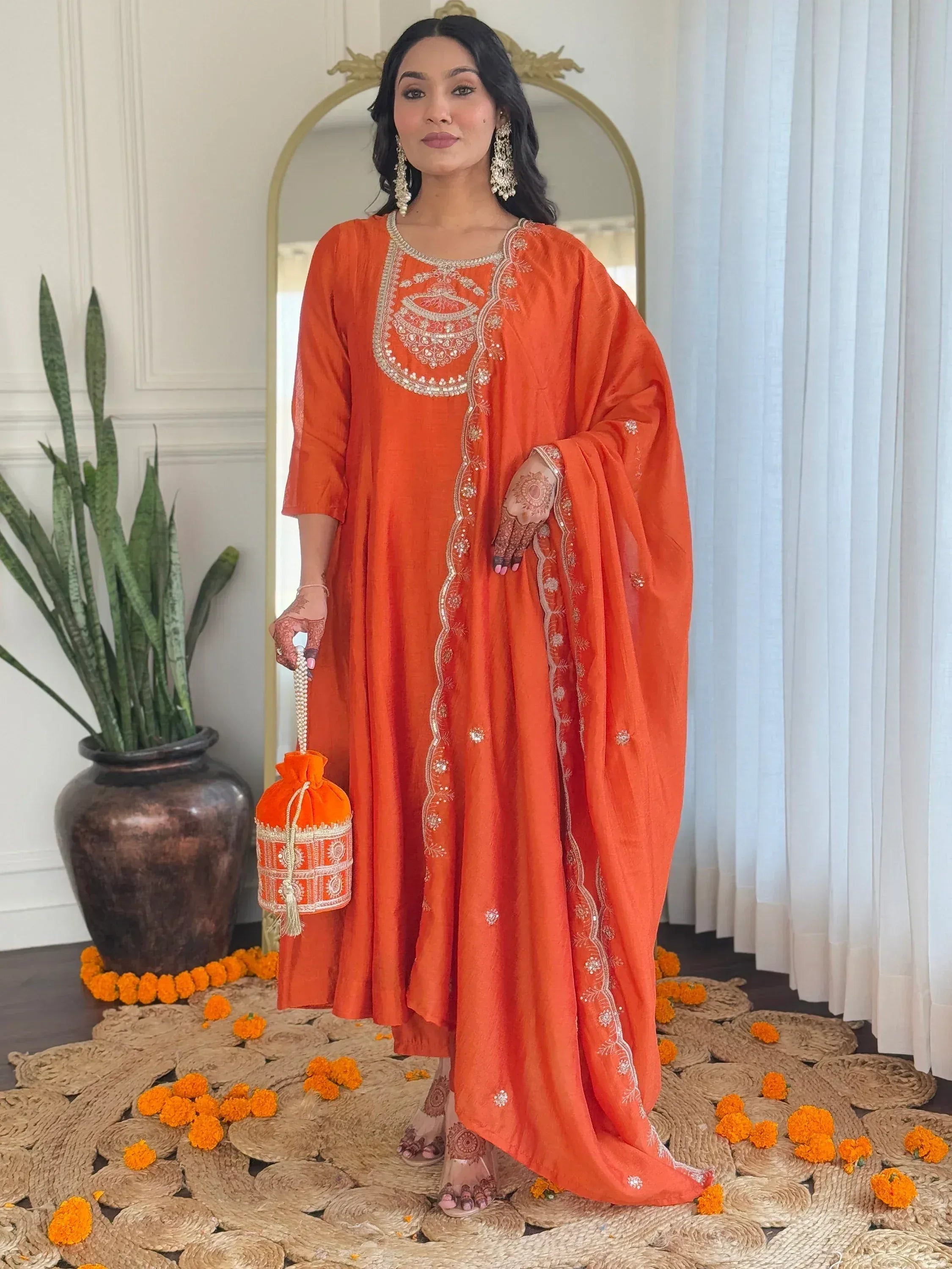 Orange embroidered ethnic kurti with matching dupatta and potli bag, perfect for festive occasions.