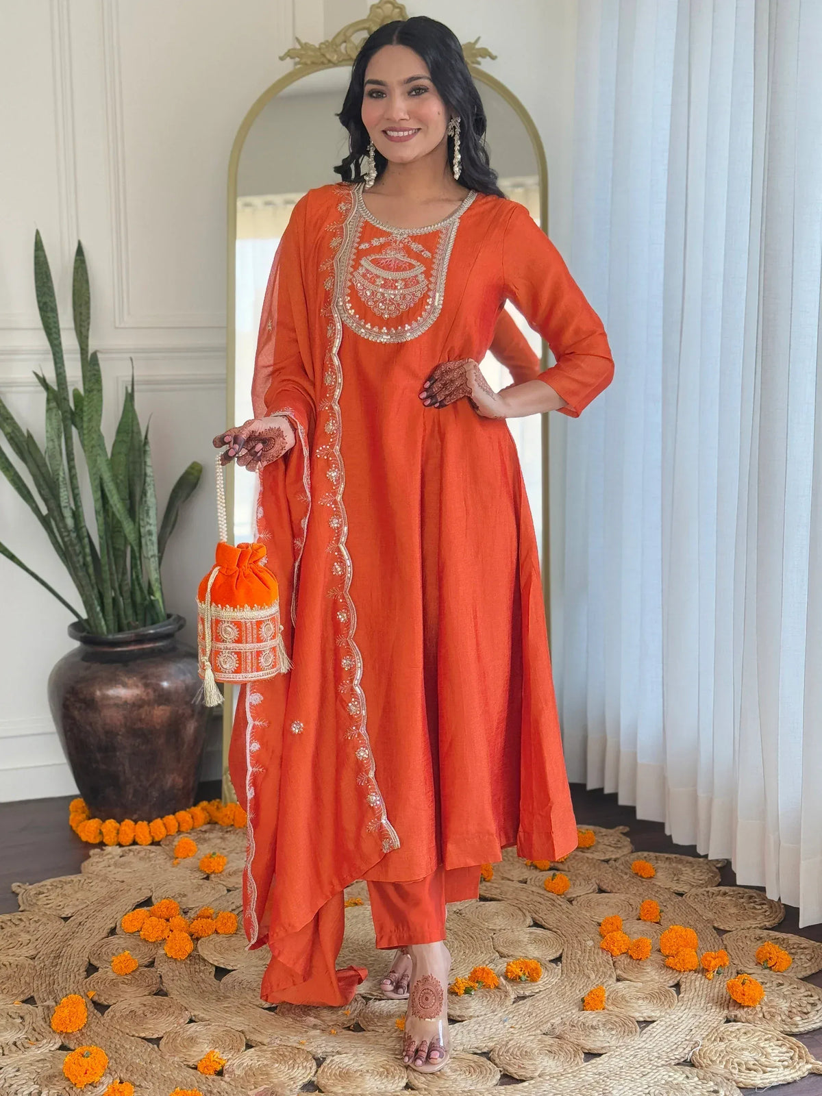 Orange embroidered kurta set with matching pants and potli bag, perfect for Indian ethnic occasions