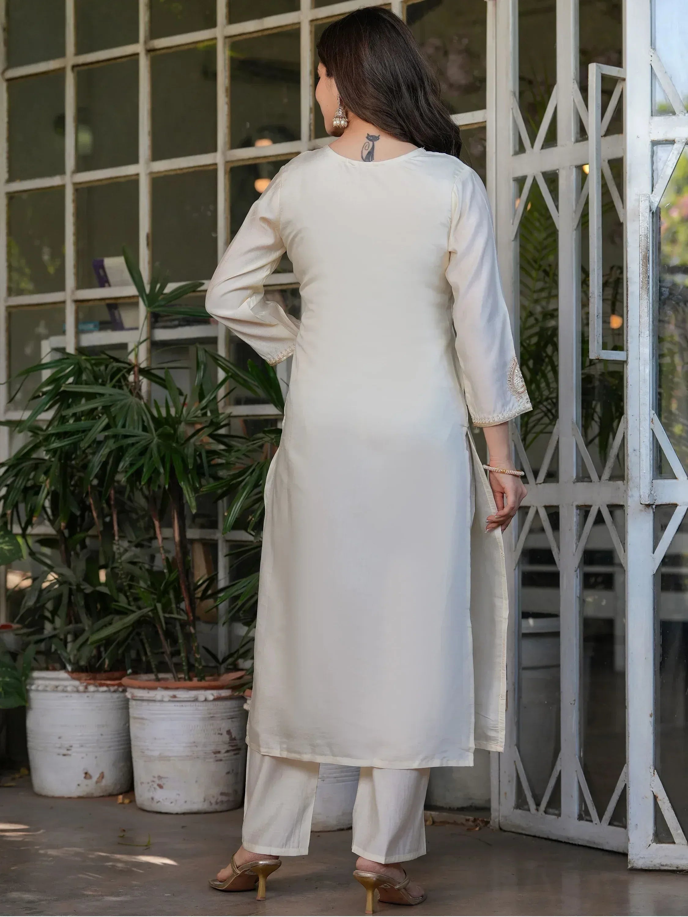 Cream embroidered kurta with palazzo pants, ethnic wear for women, back view near window