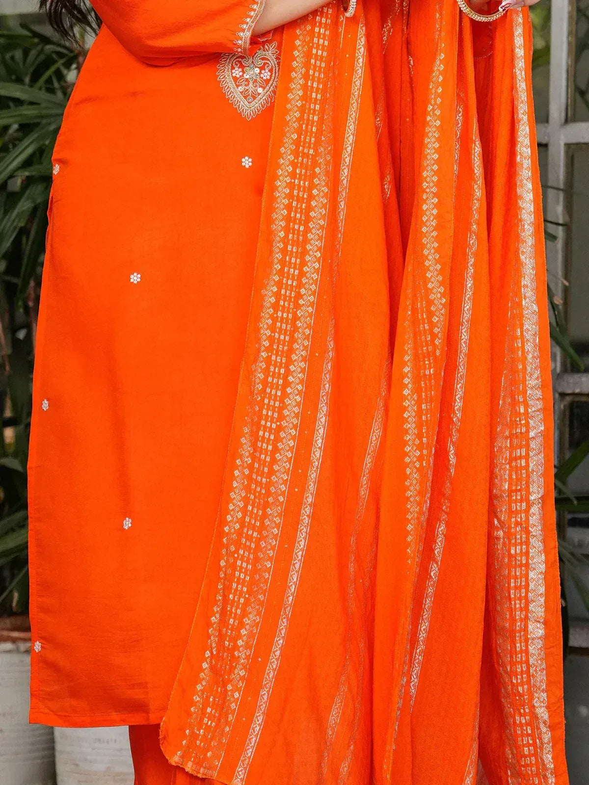 Vibrant orange salwar kameez with intricate white embroidery and matching dupatta, perfect for ethnic occasions.