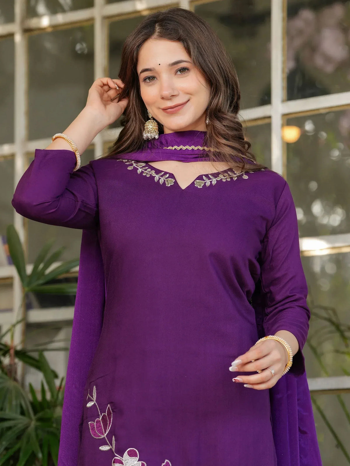 Purple ethnic kurti with floral embroidery and gold detailing, paired with statement earrings