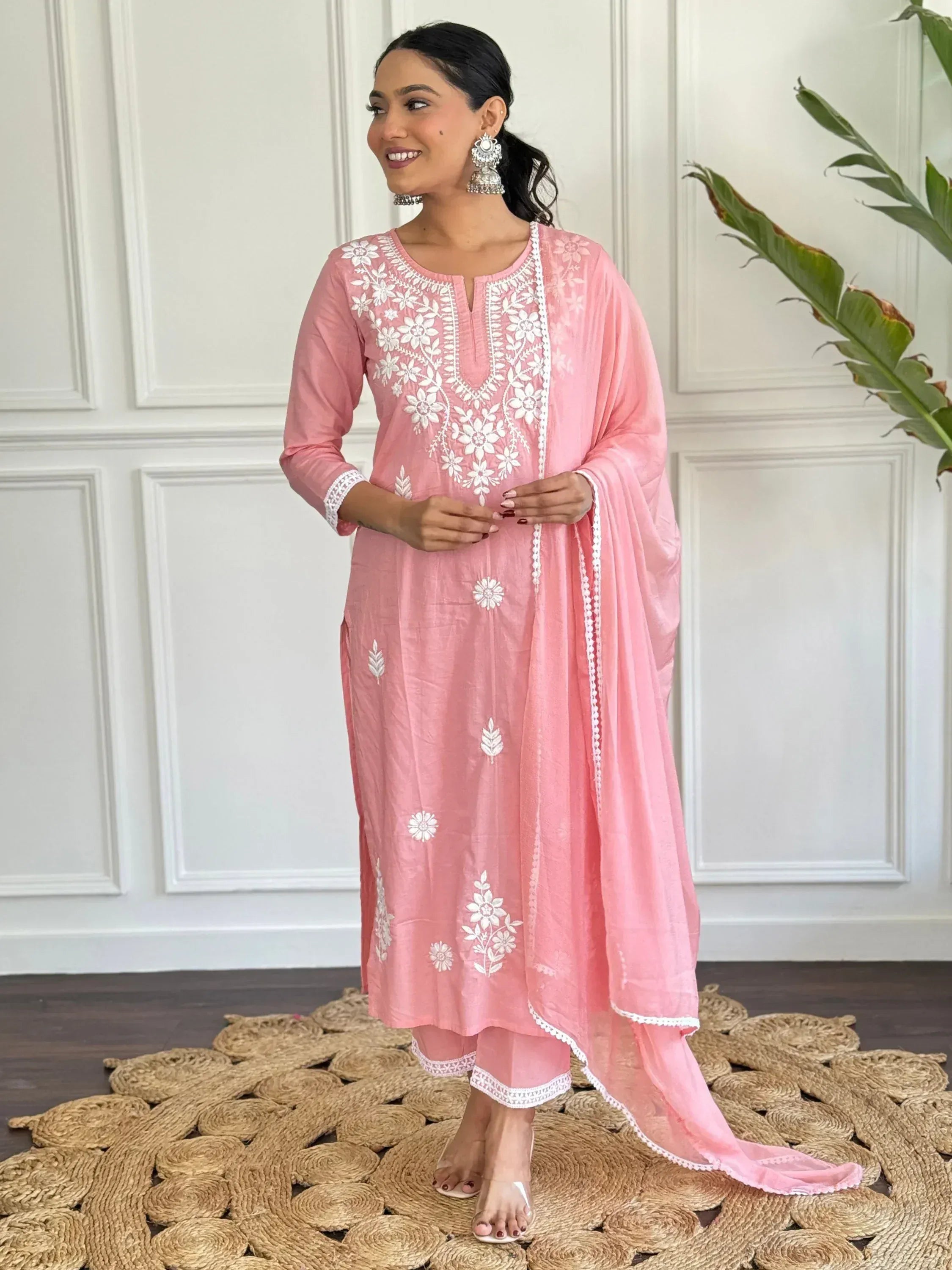 Pink embroidered salwar kameez with white floral work, matching dupatta, and traditional jewelry