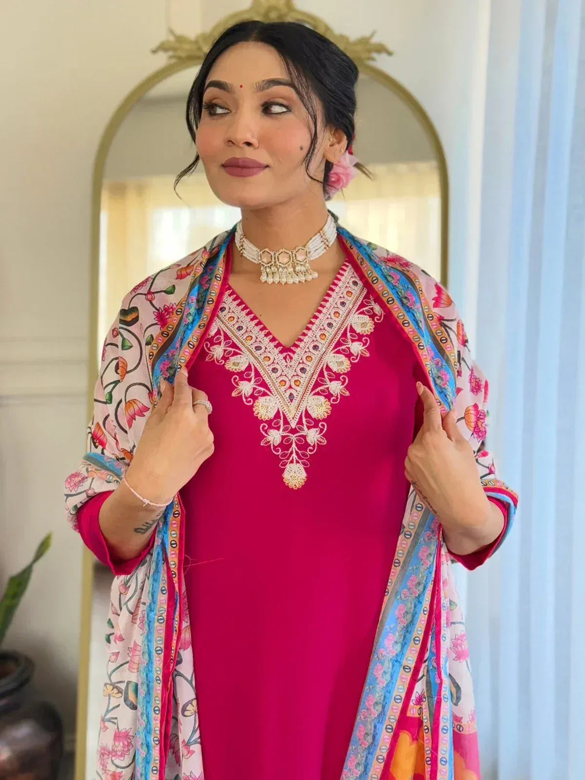Woman in vibrant pink embroidered kurta with floral dupatta, styled for Indian ethnic wear