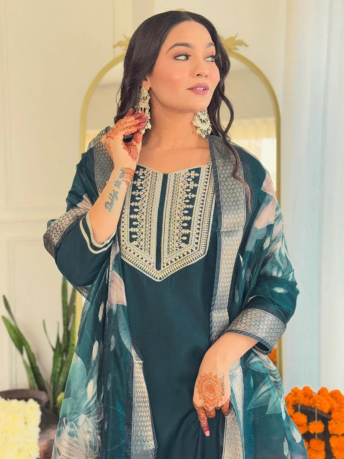 Woman in teal embroidered kurta with floral dupatta, henna hands, gold earrings, Indian ethnic wear