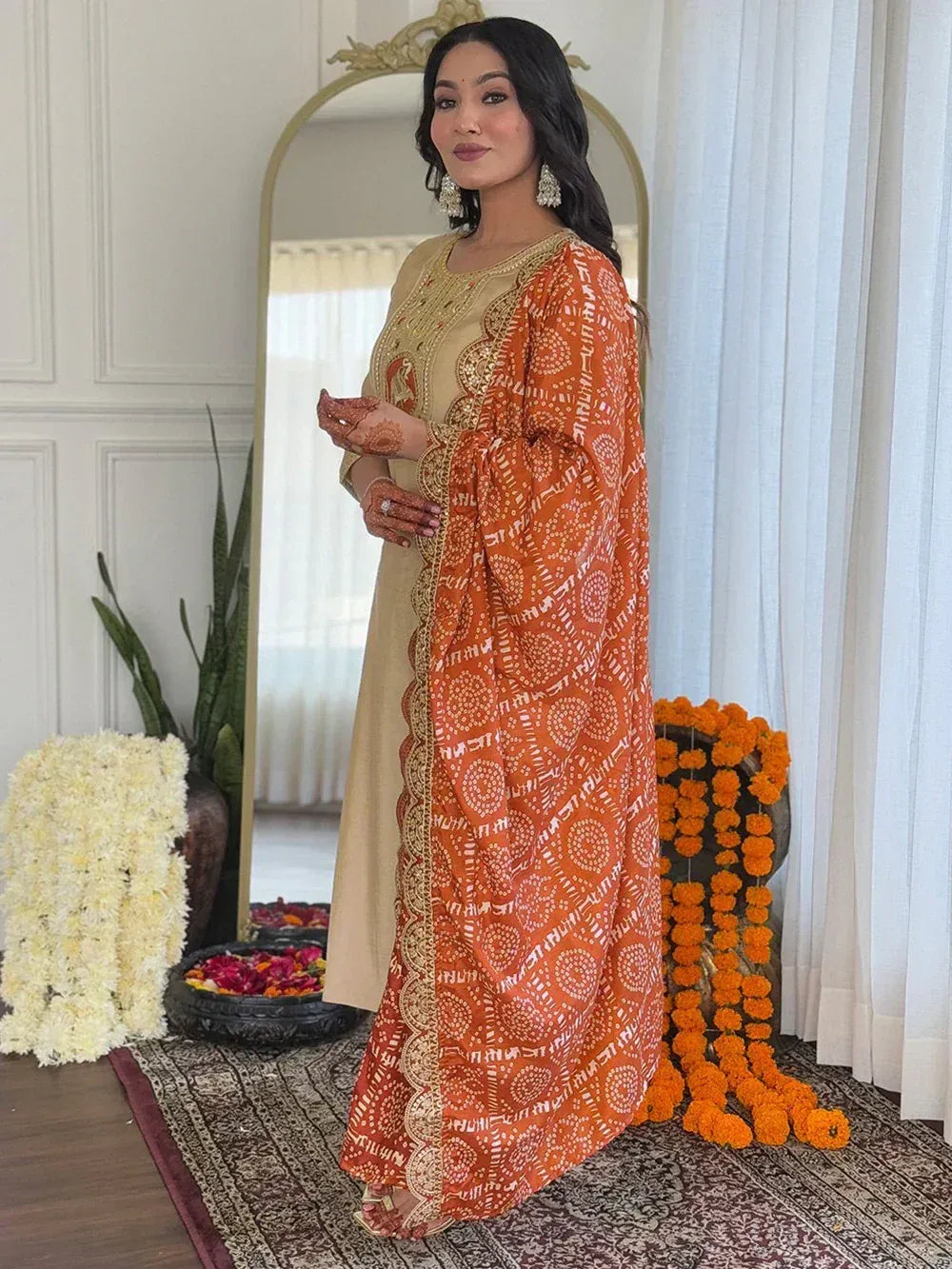 Woman in beige embroidered kurta with orange printed dupatta, ethnic Indian wear for festive occasions