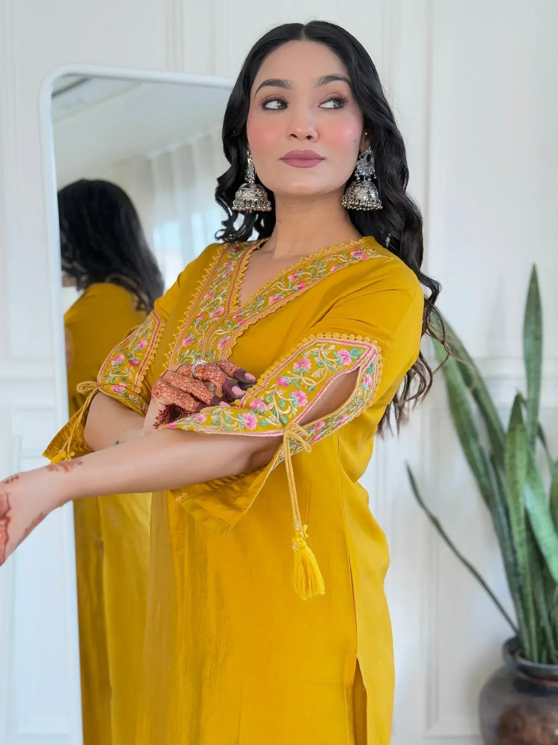 Yellow embroidered ethnic kurta with floral detailing, jhumka earrings, and henna hands