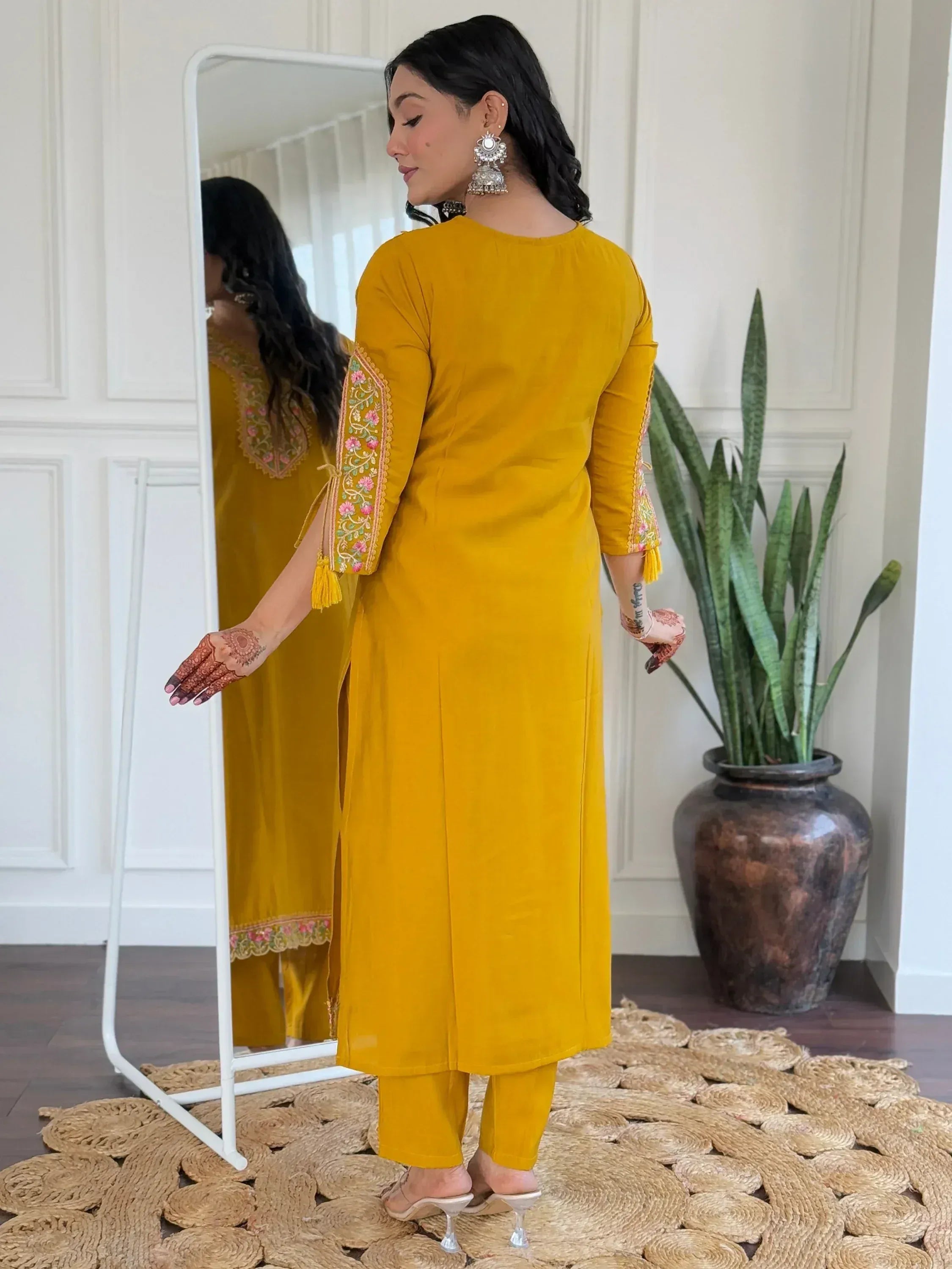 Mustard yellow embroidered kurta set with floral sleeves, henna hands, and jhumka earrings for ethnic wear