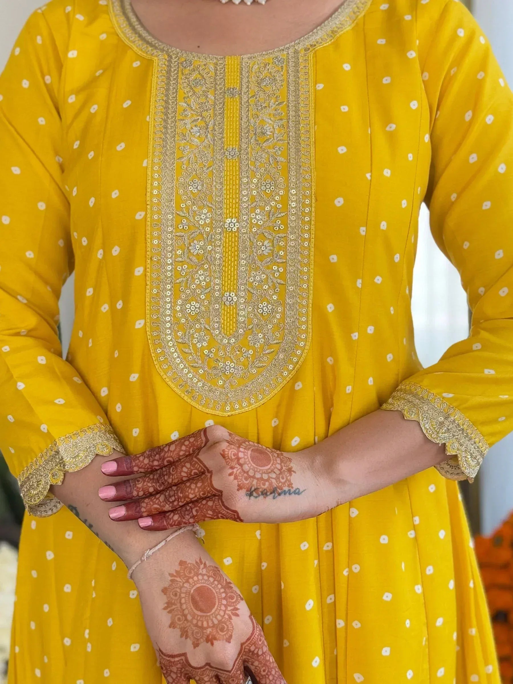 Yellow ethnic kurta with gold embroidery and white polka dots, paired with henna hands
