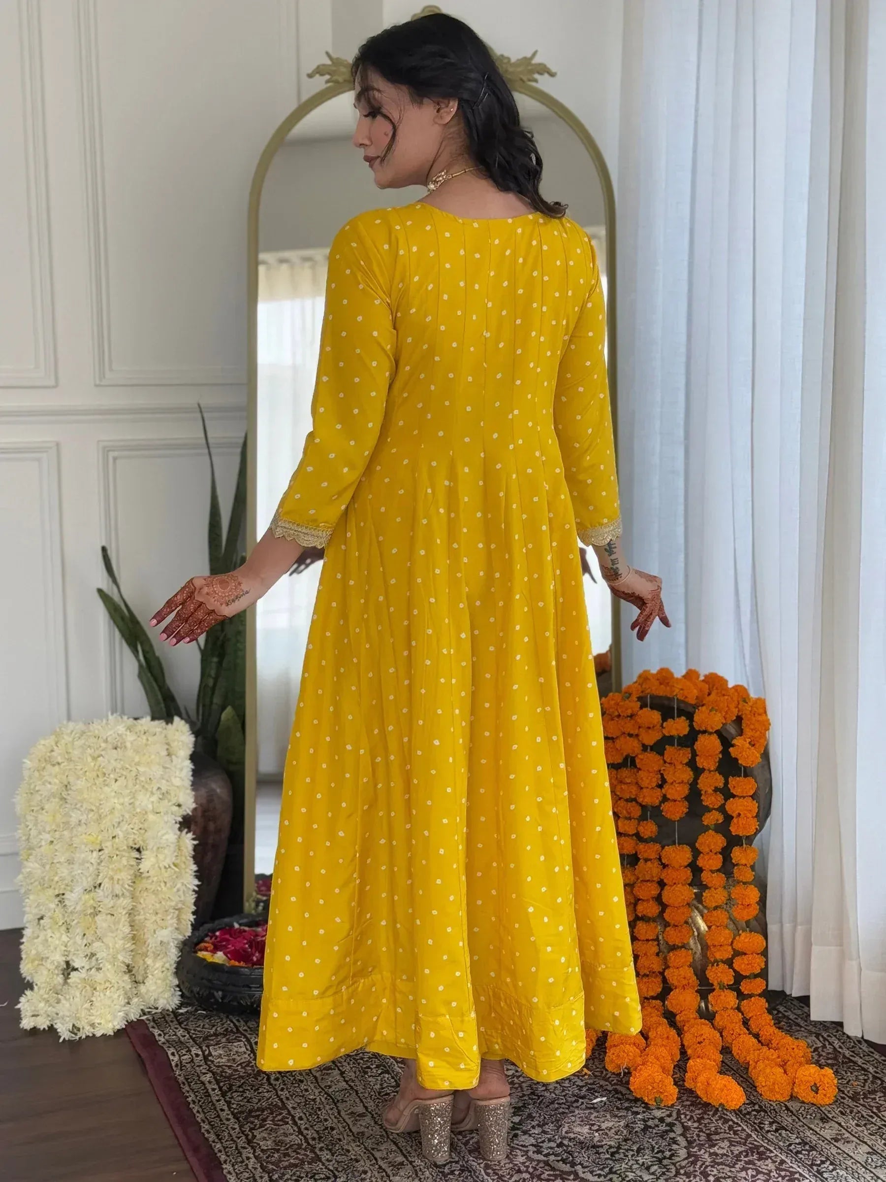 Yellow polka dot ethnic gown with lace cuffs, perfect for Indian celebrations and festive occasions.